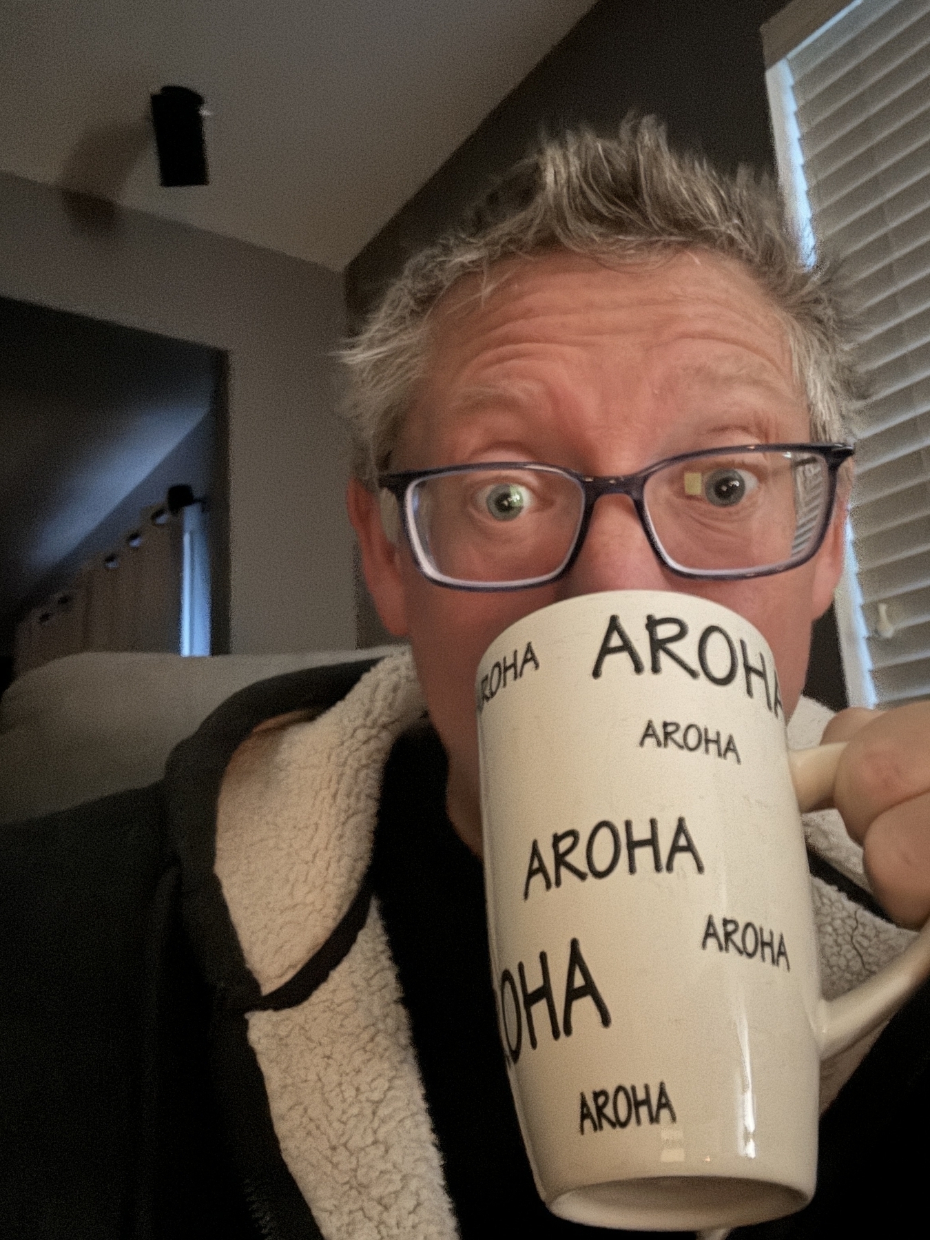 A Dan with a mug of coffee that says, “Aroha” the Māori word for “love”
