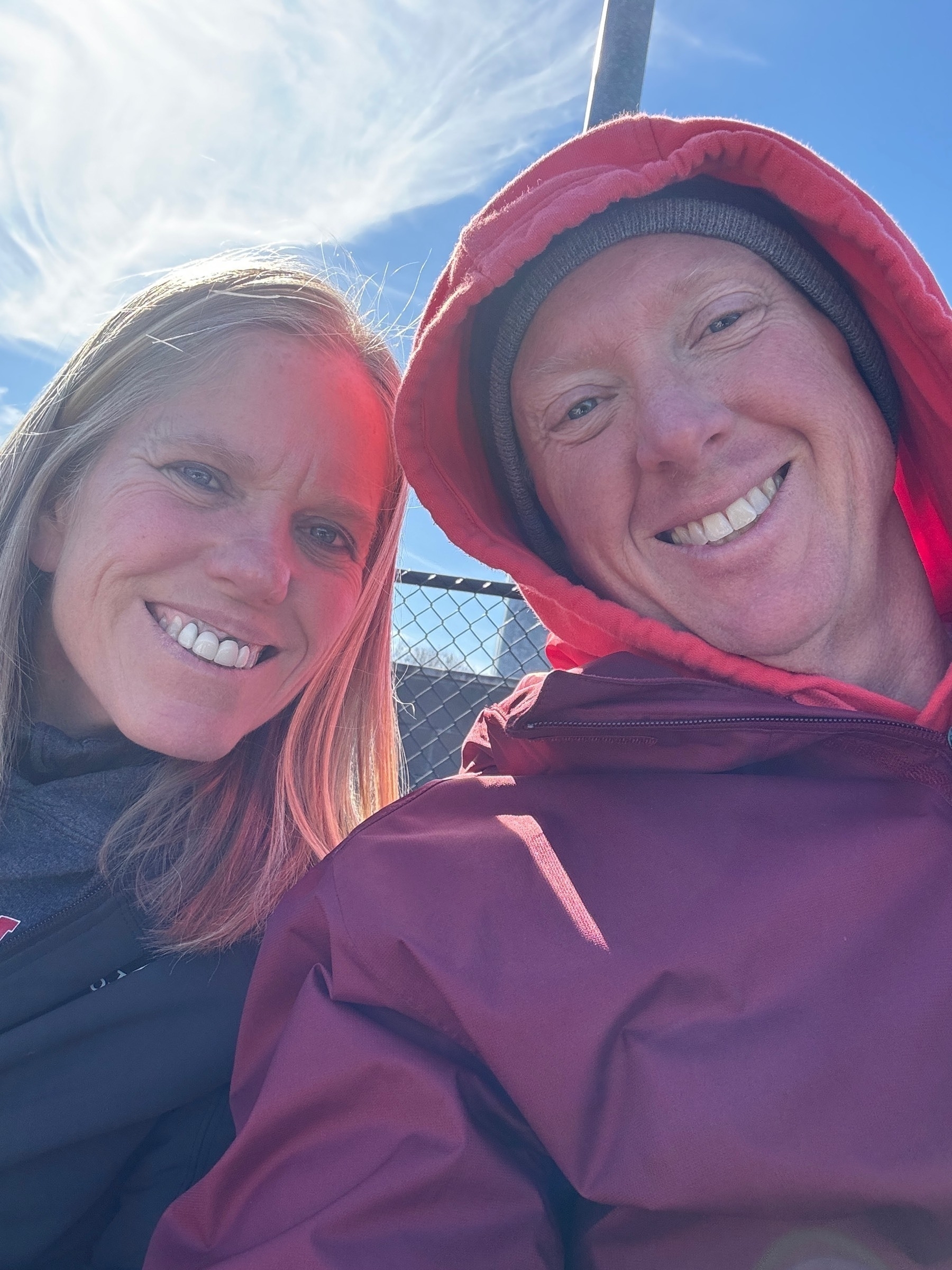 My wife and I freezing at a baseball game on a windy spring afternoon. 