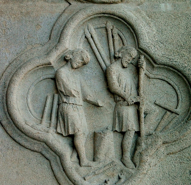Auto-generated description: A stone relief depicts two figures in medieval attire, each holding long spears, engaging in conversation.