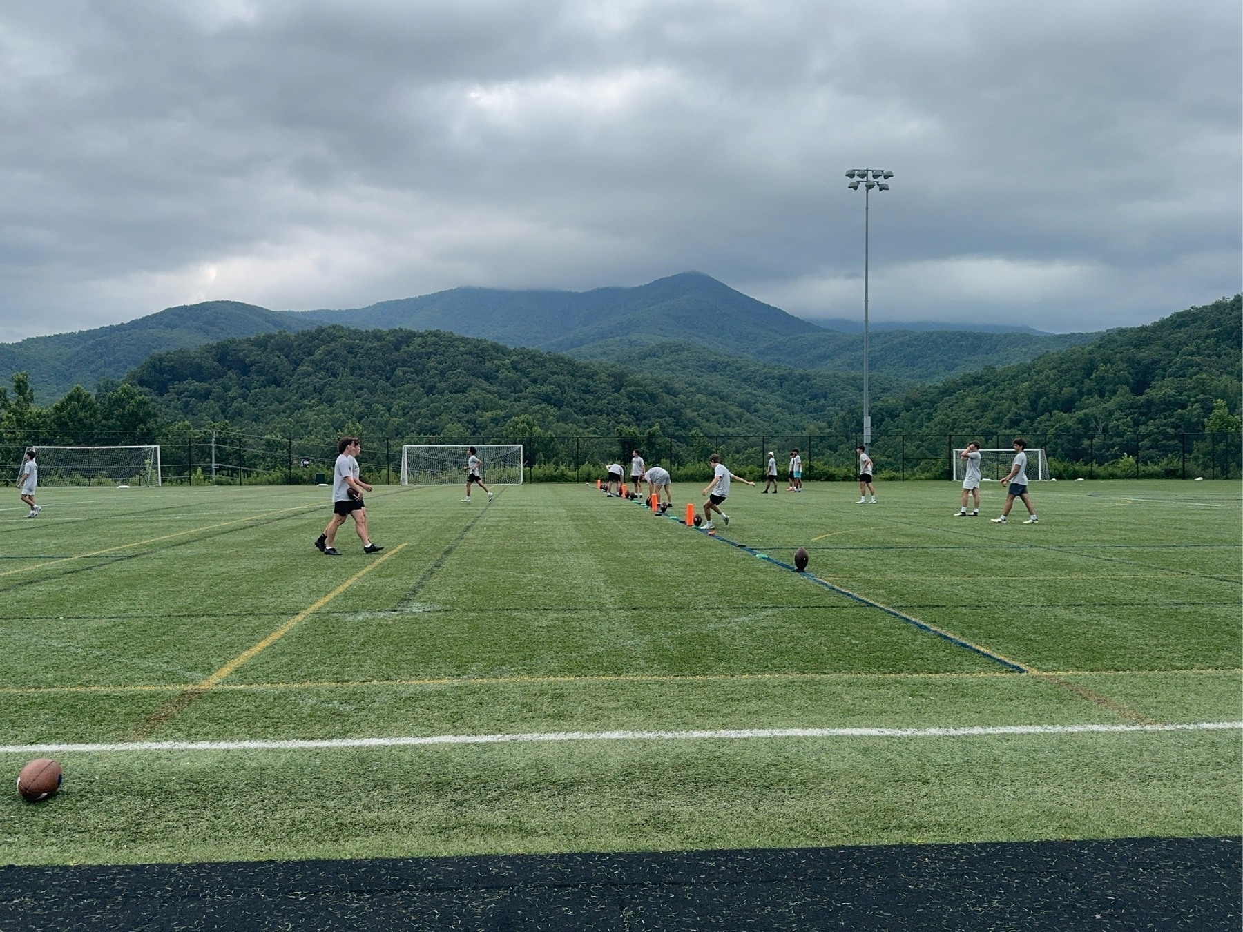 Scenic view of the smokey mountains behind a football field full if kickers