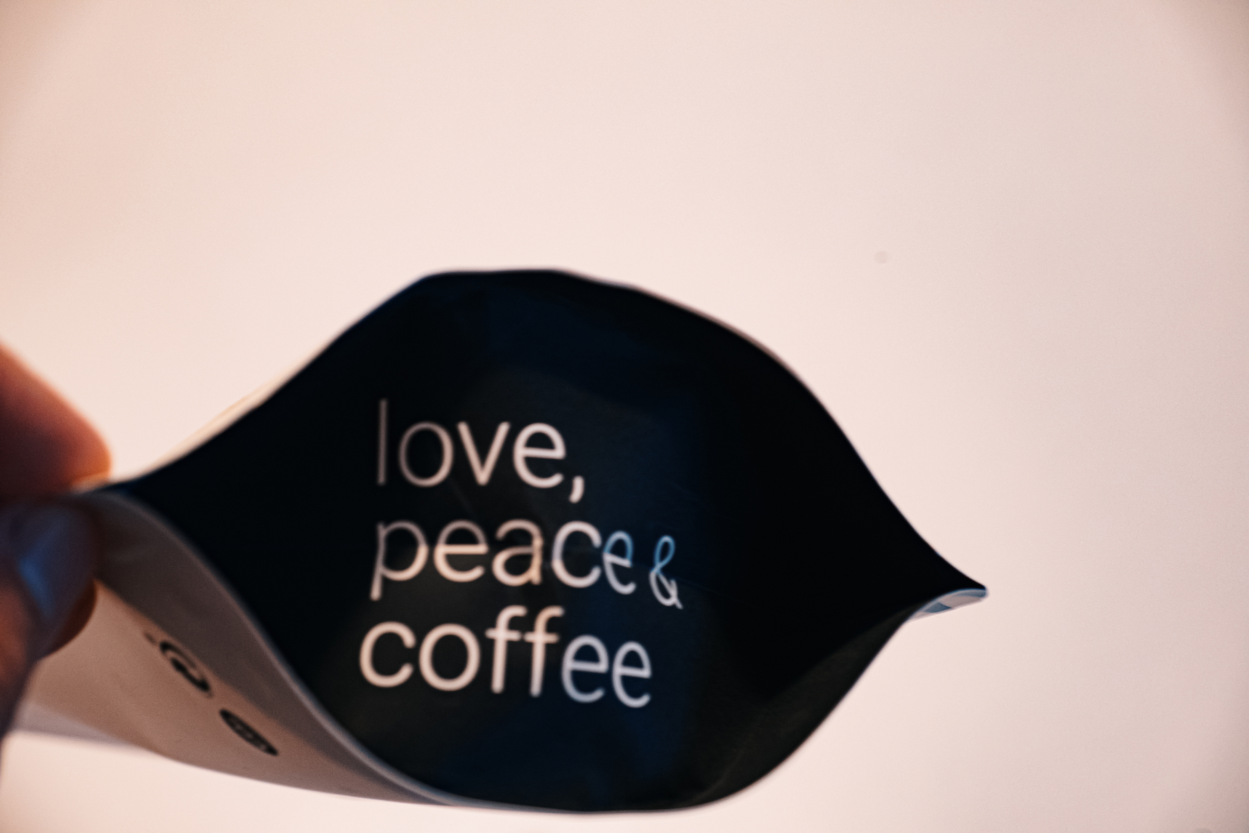 Die Rückseite meiner Lieblingskaffeeverpackung mit dem Satz "Liebe, Frieden & Kaffee" darauf geschrieben.