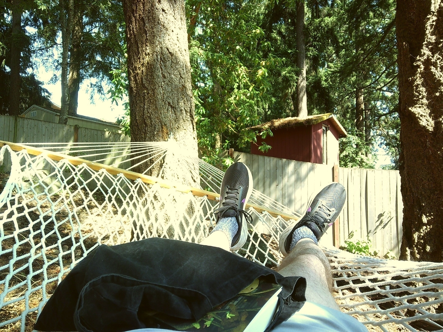 A pov shot of shoes while laying in a hammock, out in the sunshine