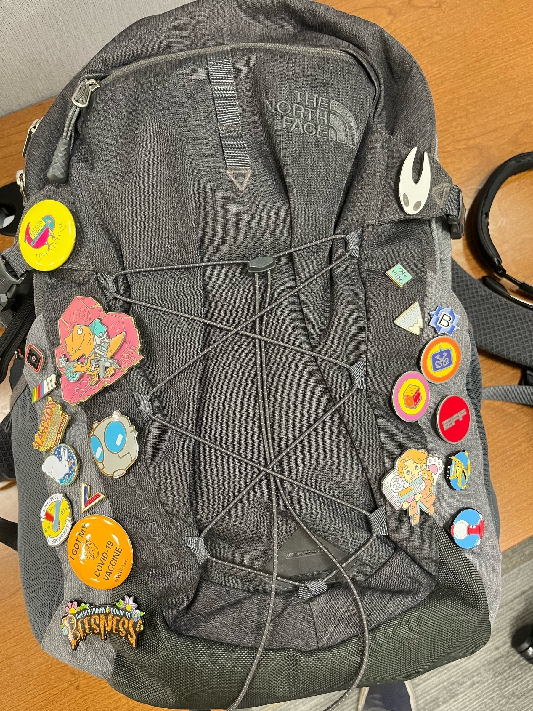 A North Face Borealis backpack covered in a variety of pins including ATP, MBMBAM, BBEdit and Critical Role.