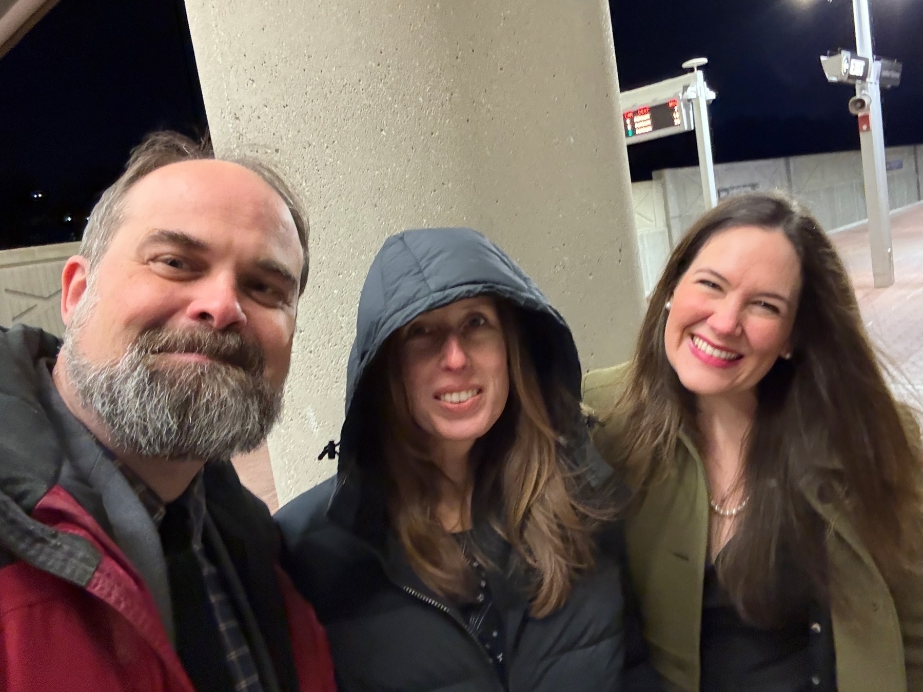 Sam, Kat, and Amy smile at the metro station