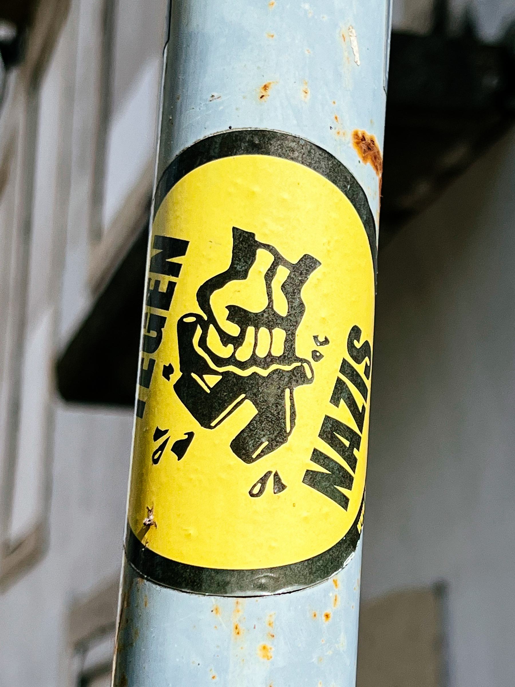 Sticker of a hand smashing a swastika, with the word “nazi” visible.  