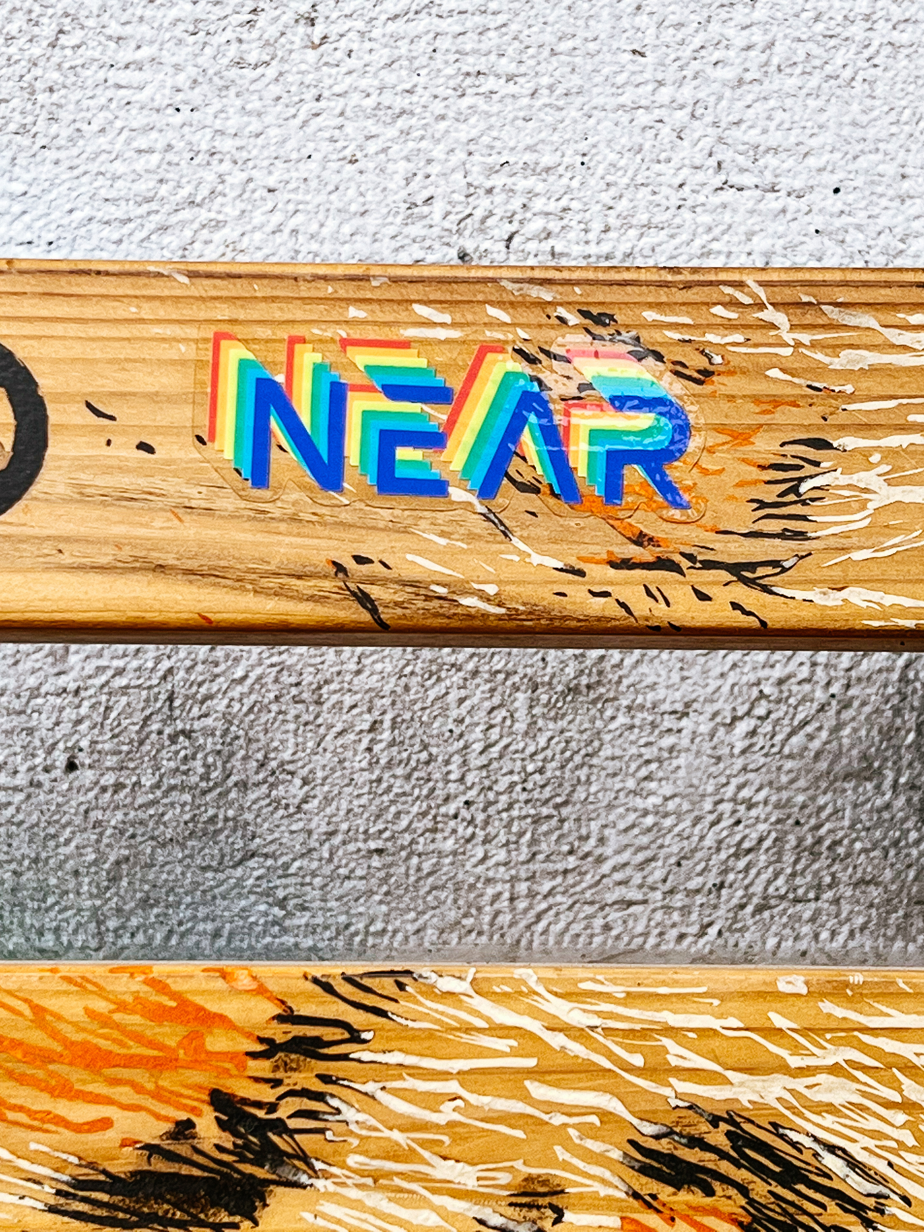 Sticker with the word “Near” written on a rainbow colored font. 