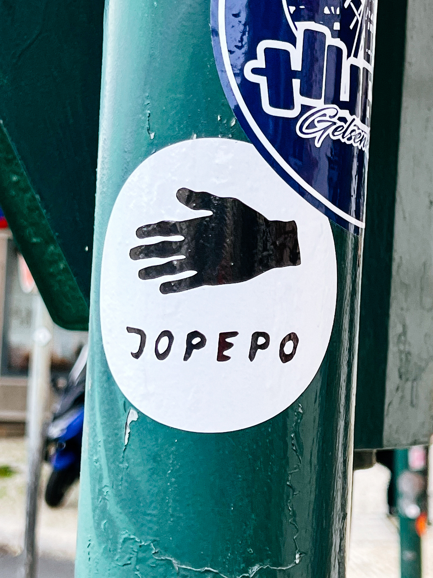 Sticker with the drawing of a hand and the word “Jopepo”. 