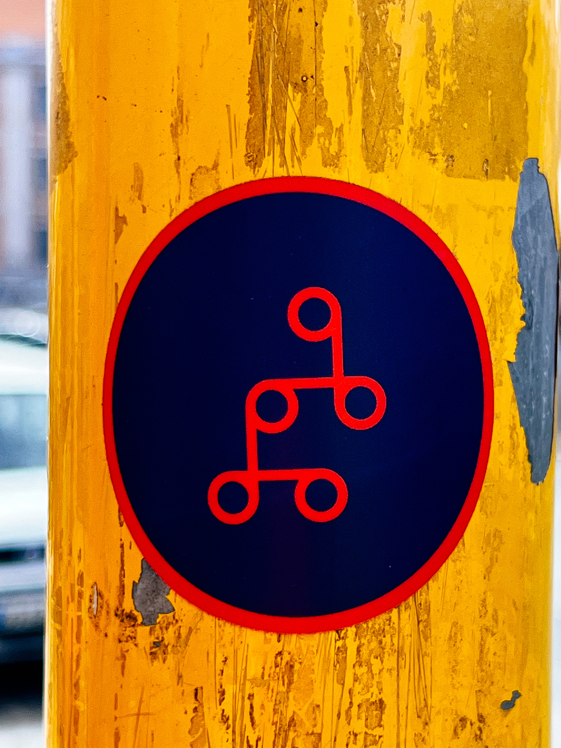 Sticker of several connected red circles, on a blue background. 