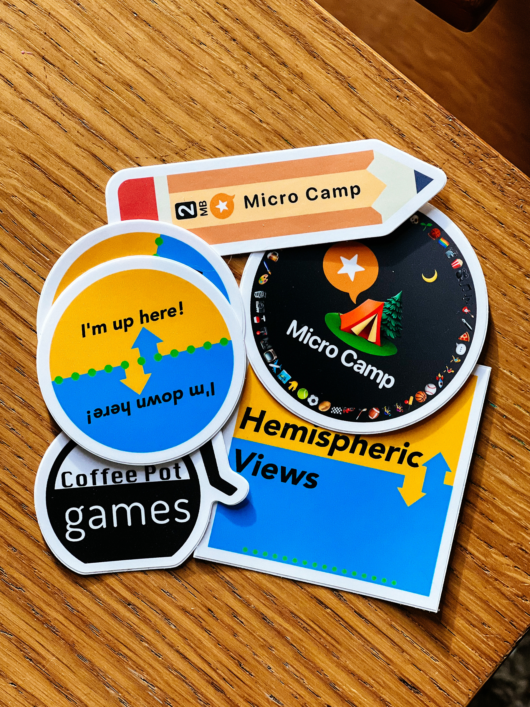 A bunch of sticker on a table. Hemispheric Views, Micro.camp, and a few others.