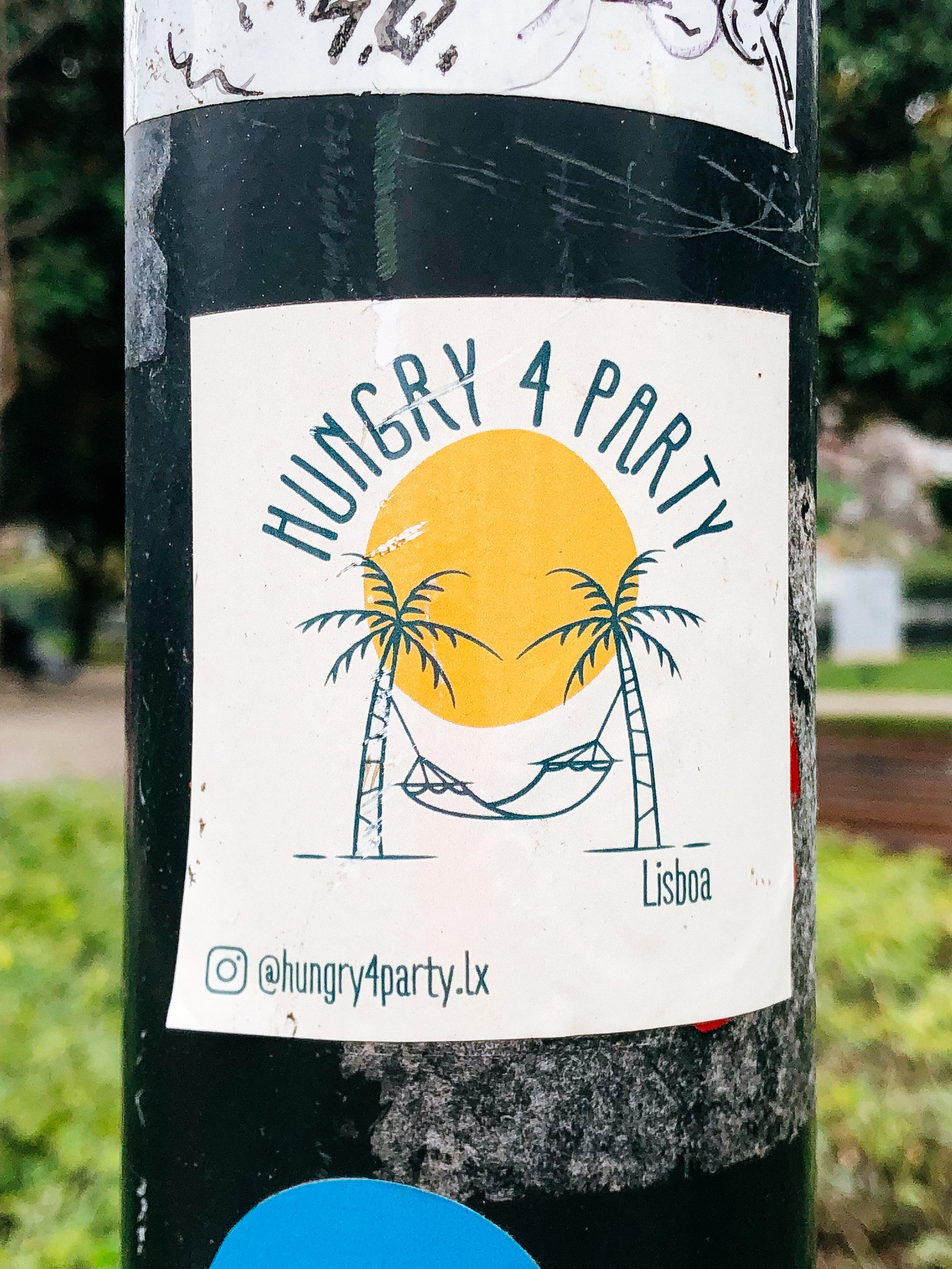 Sticker with a hammock, two palm trees, and the sun. “Hungry 4 party” written above it. 