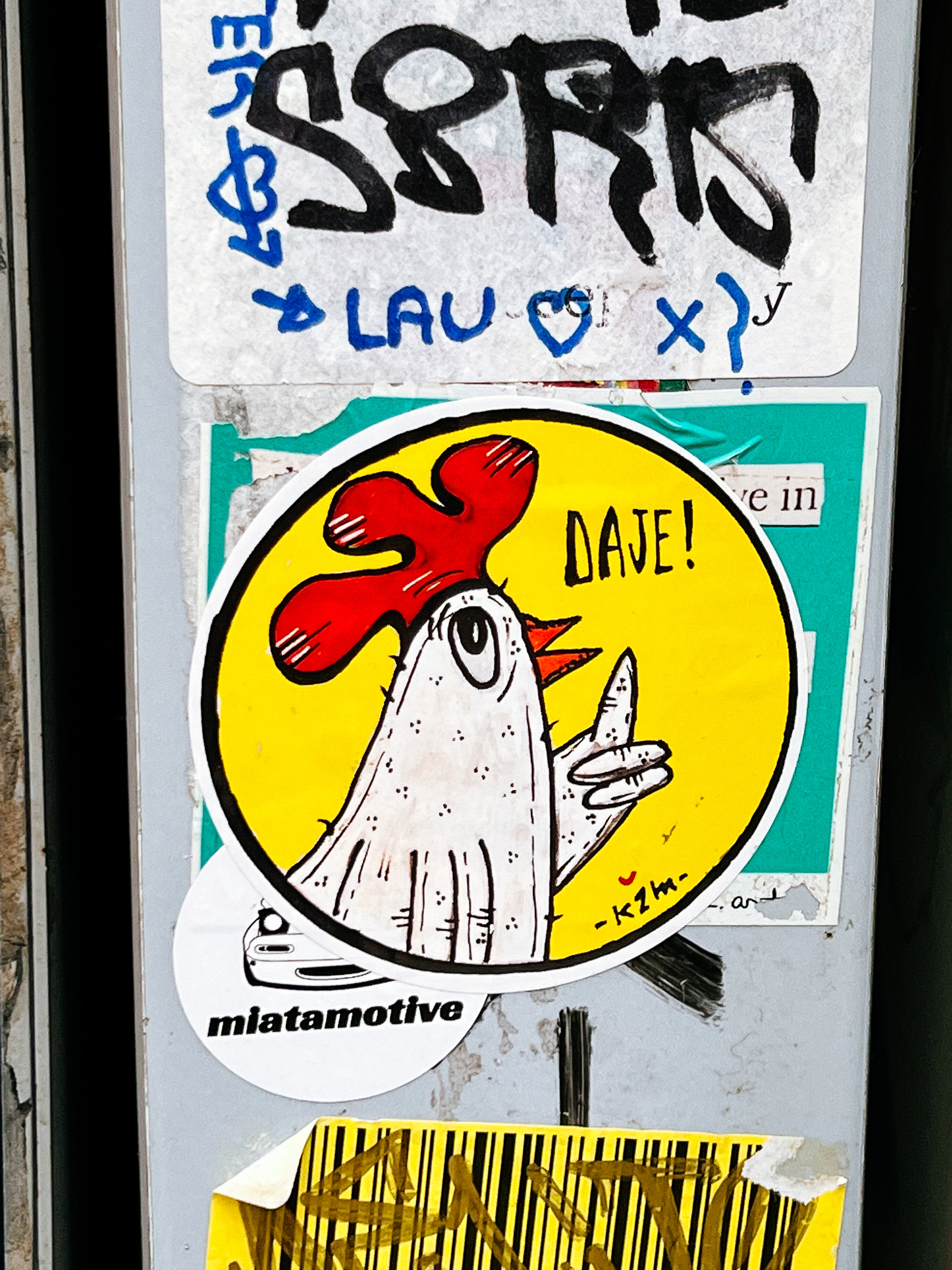 Sticker of a cartoonish chicken with a raised finger, and the word “Daje!”