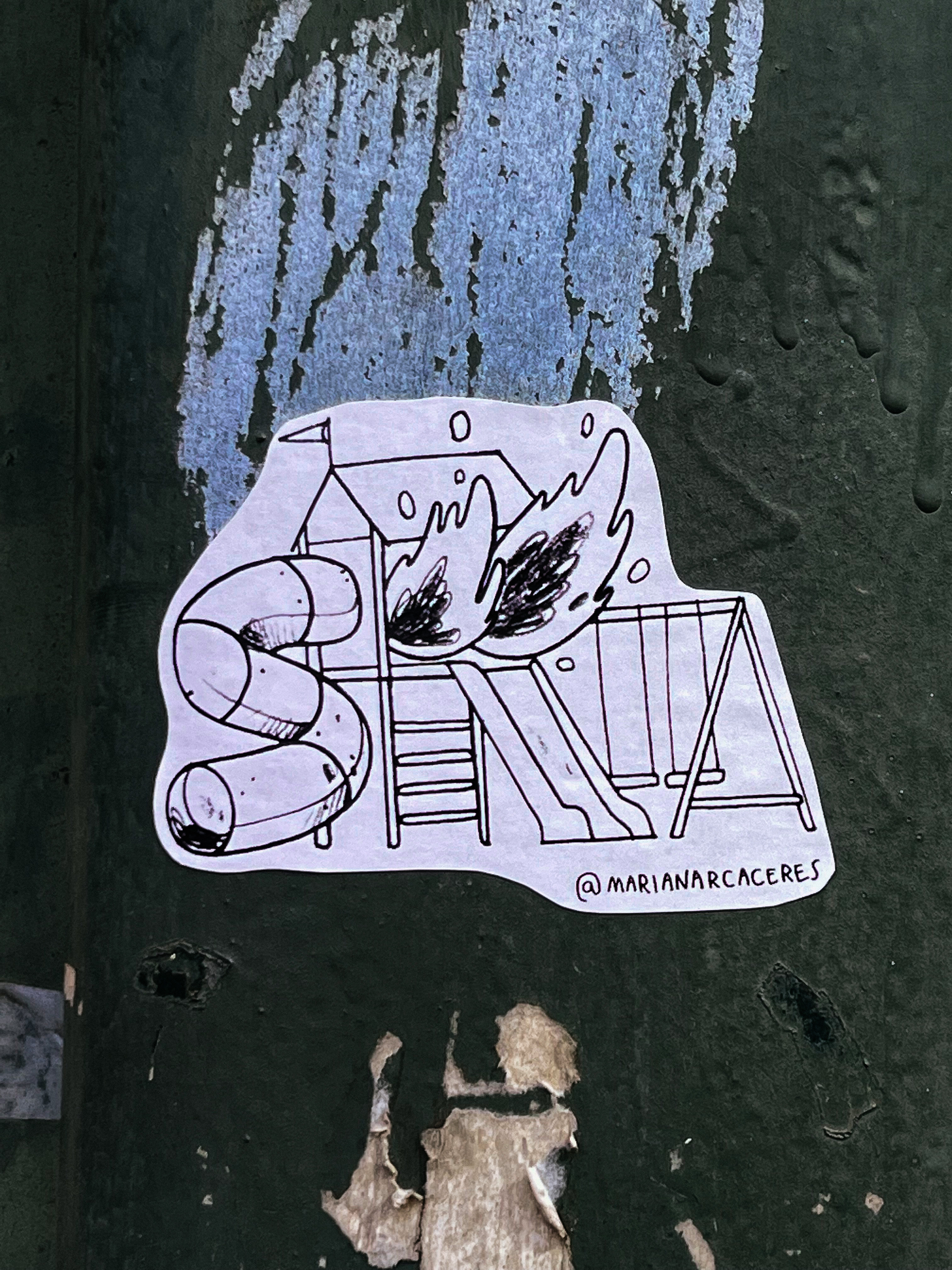 Sticker with a drawing of a children’s playground on fire. 