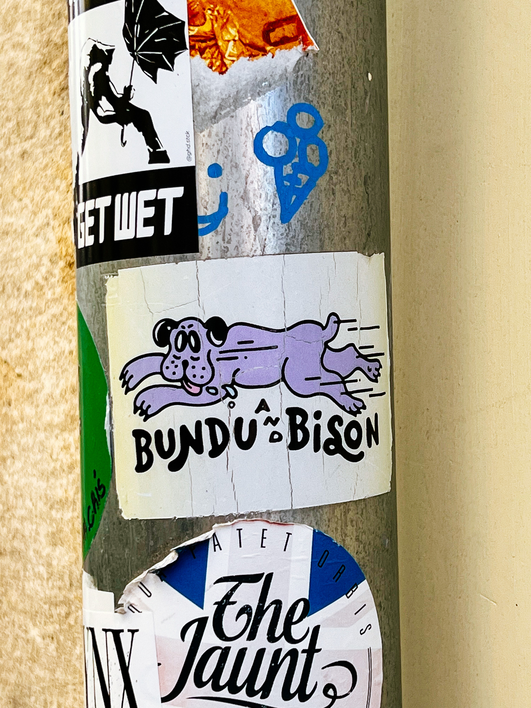 Sticker of a cartoon dog running, with the words “Bundu and Bison” written on it. 