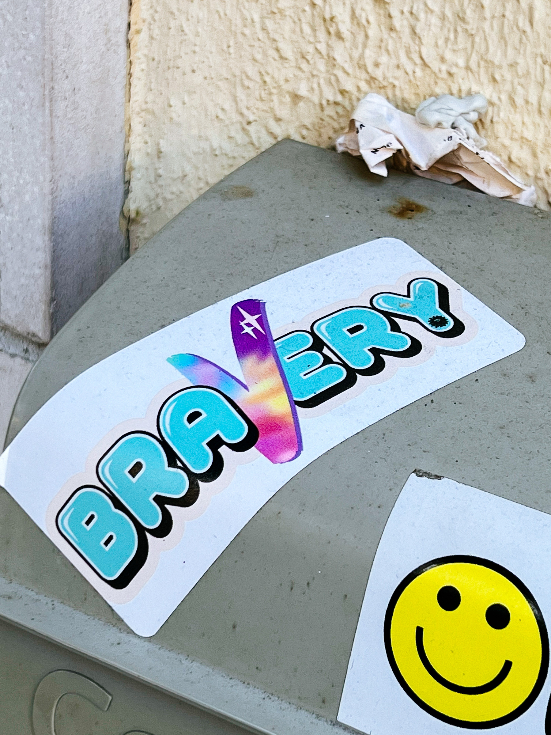 A sticker with the word “Bravery”, and another one with a smiley. 