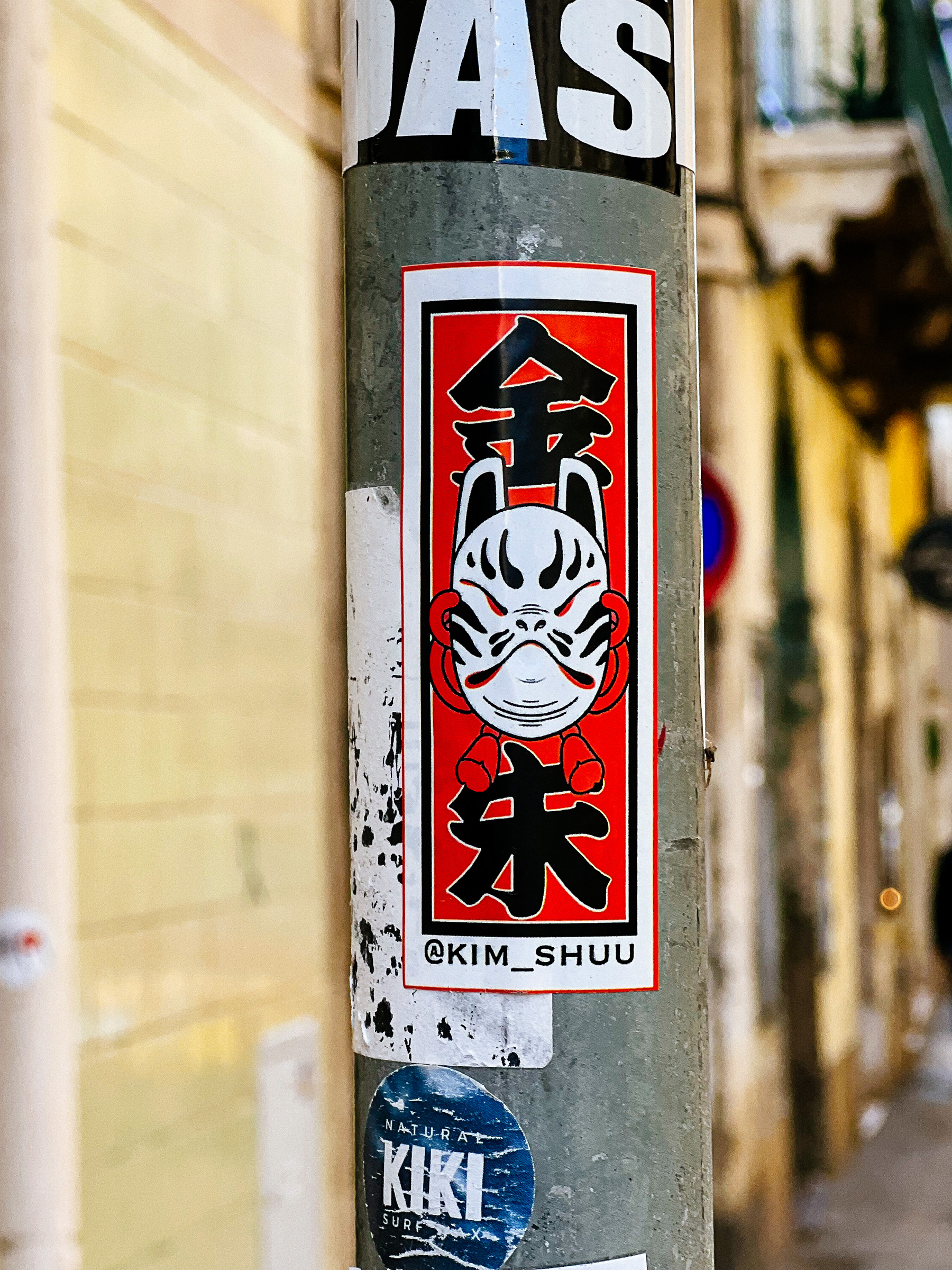 A sticker with a Japanese mask and characters. 
