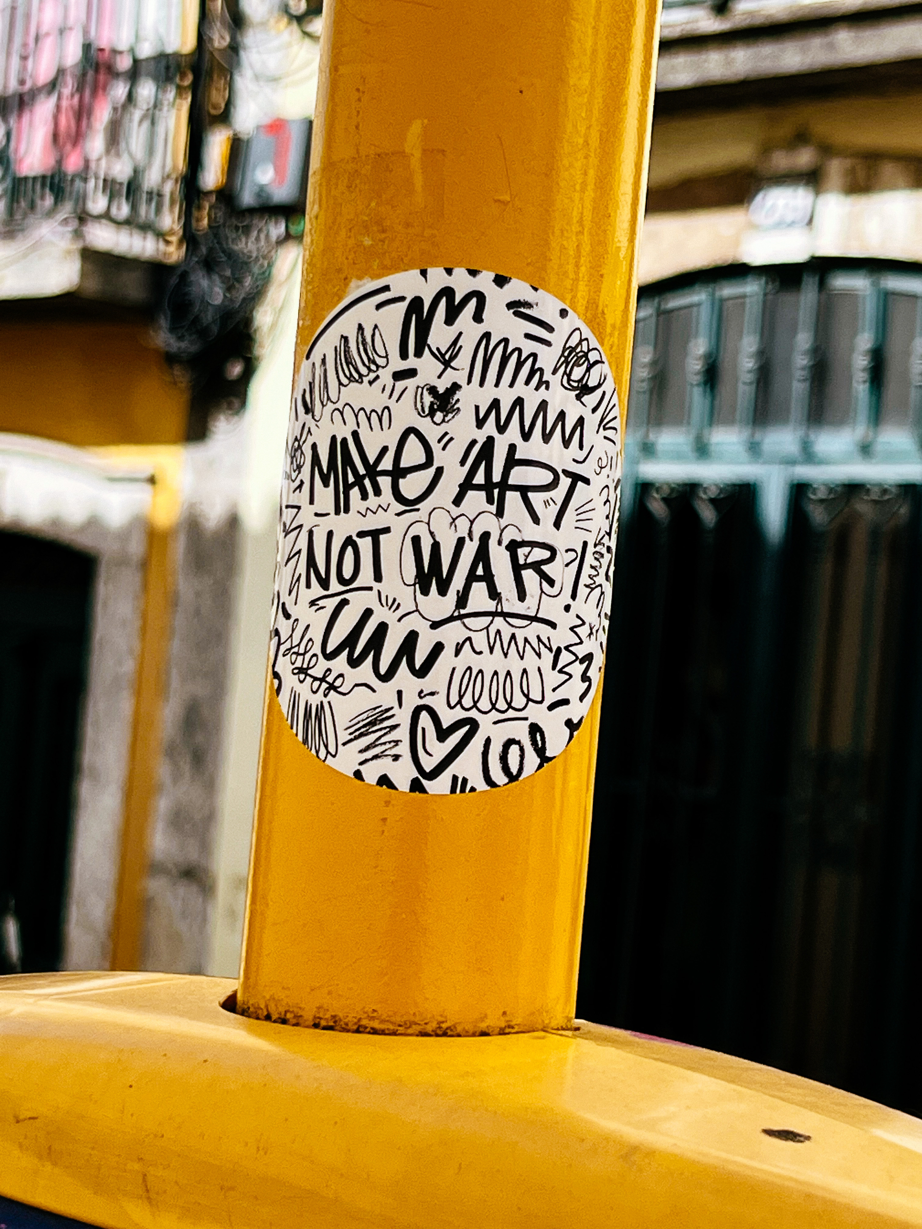 Sticker with the words “make art not war”. Handwritten.  