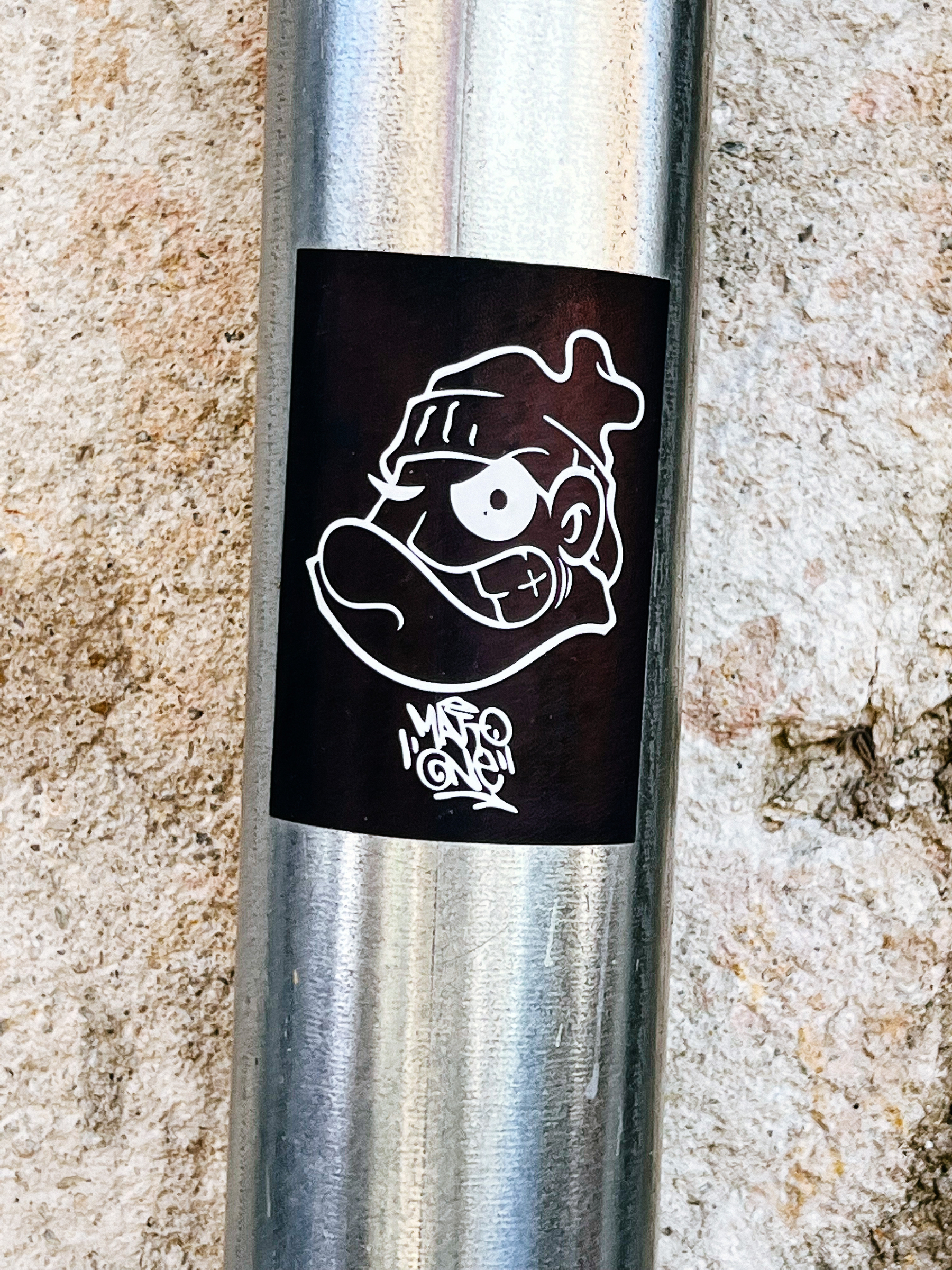 Sticker of a cartoon drawing of a tough guy clenching his jaw, wearing a beanie. 