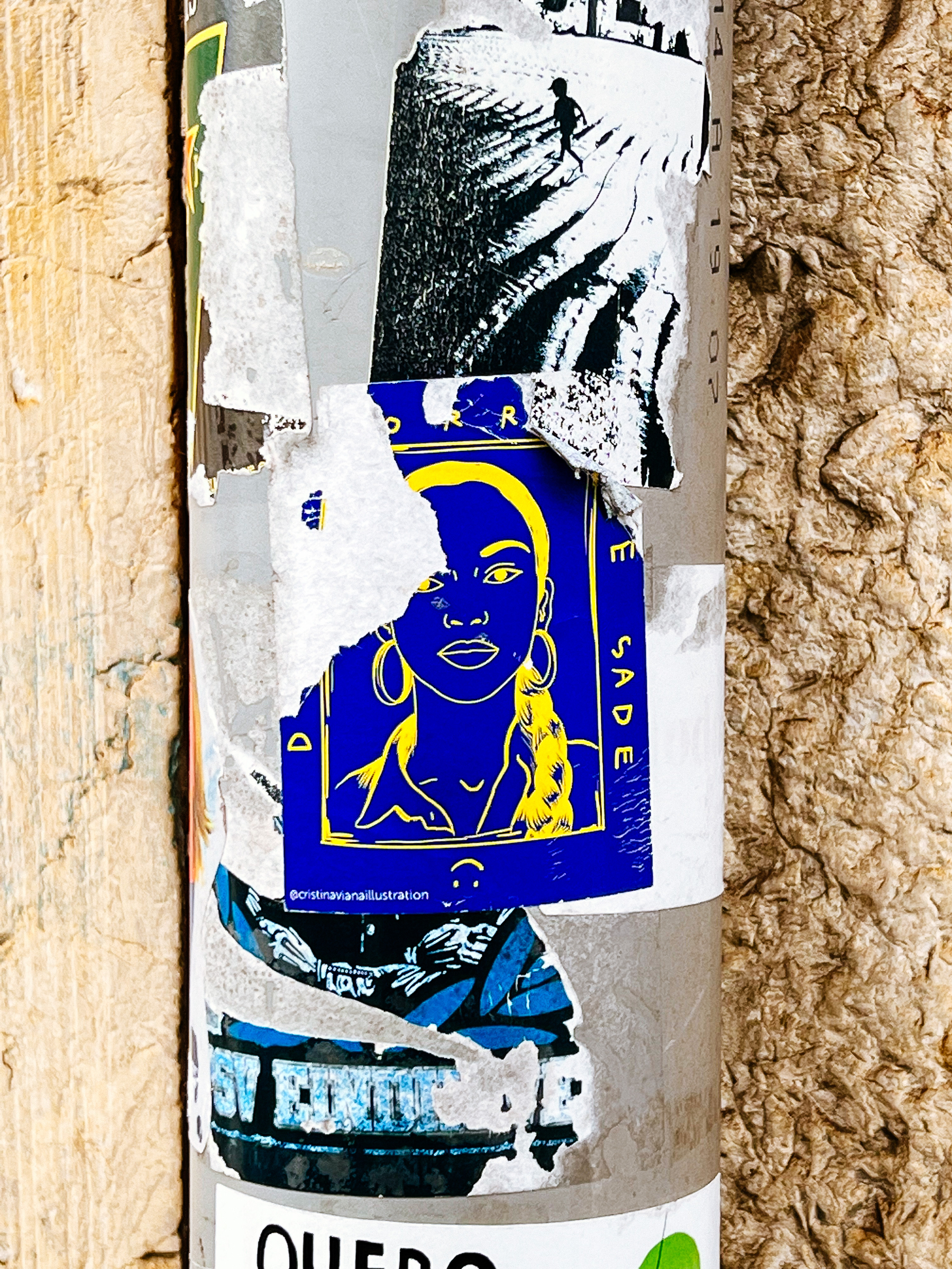 Yellow on blue drawing on a sticker with Sade’s face. 