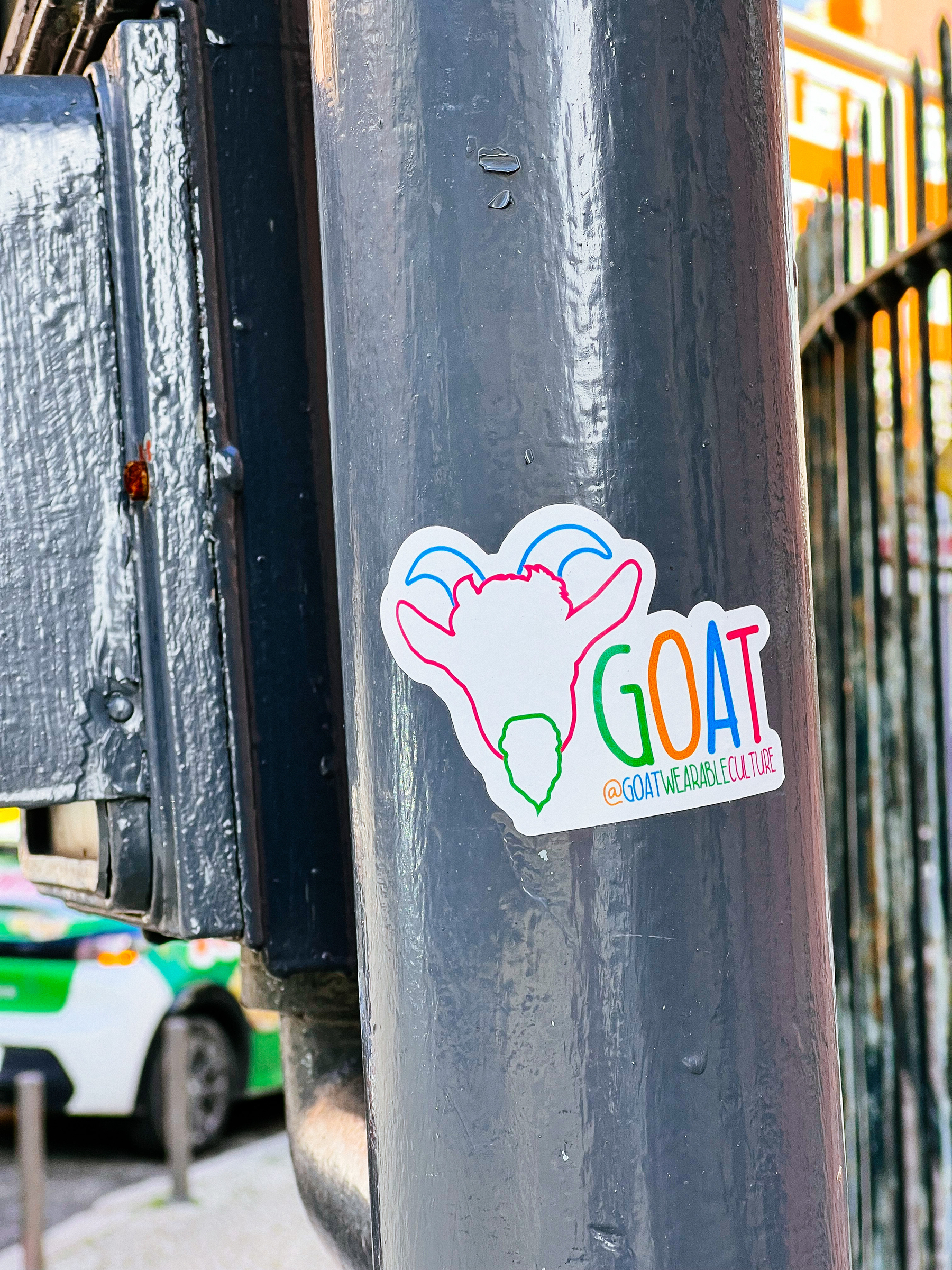 A sticker with a line outline of a goat, and the word “GOAT” next to it. 