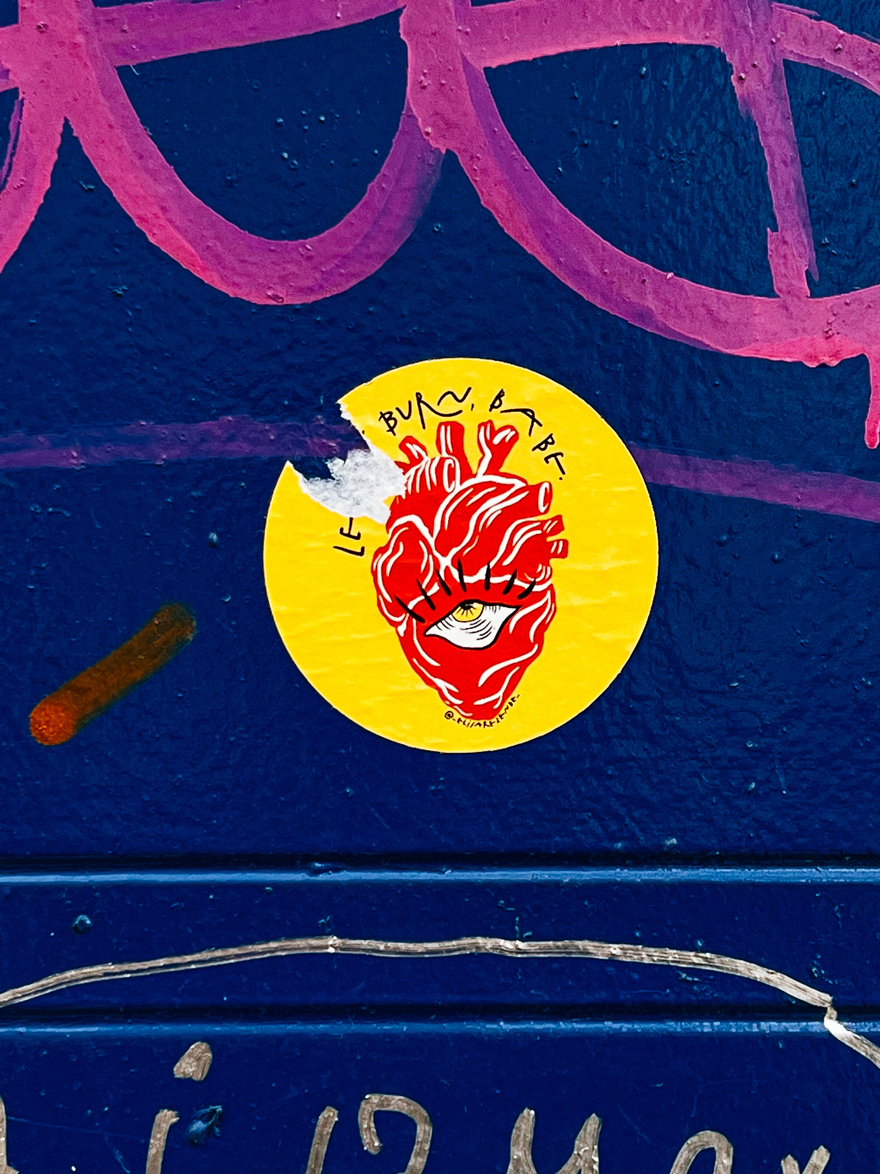 Sticker with a drawing of a red human heart with an eye, and the words “let it burn, baby”. 
