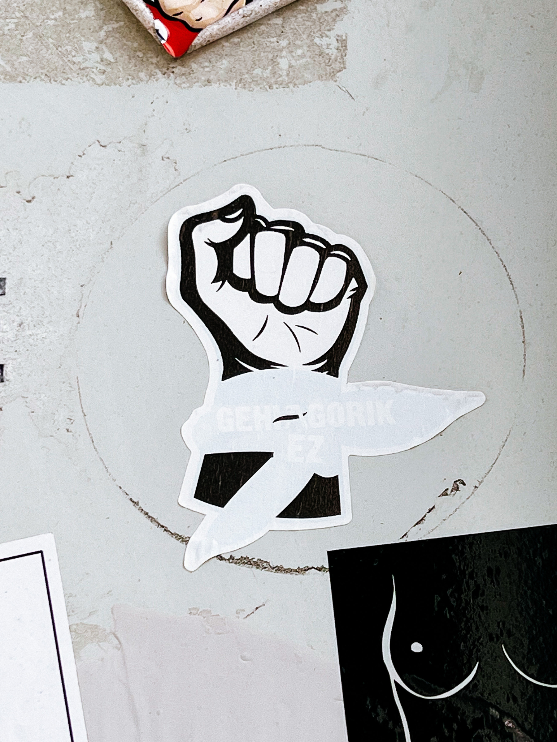 Sticker with the drawing of a clenched fist. 