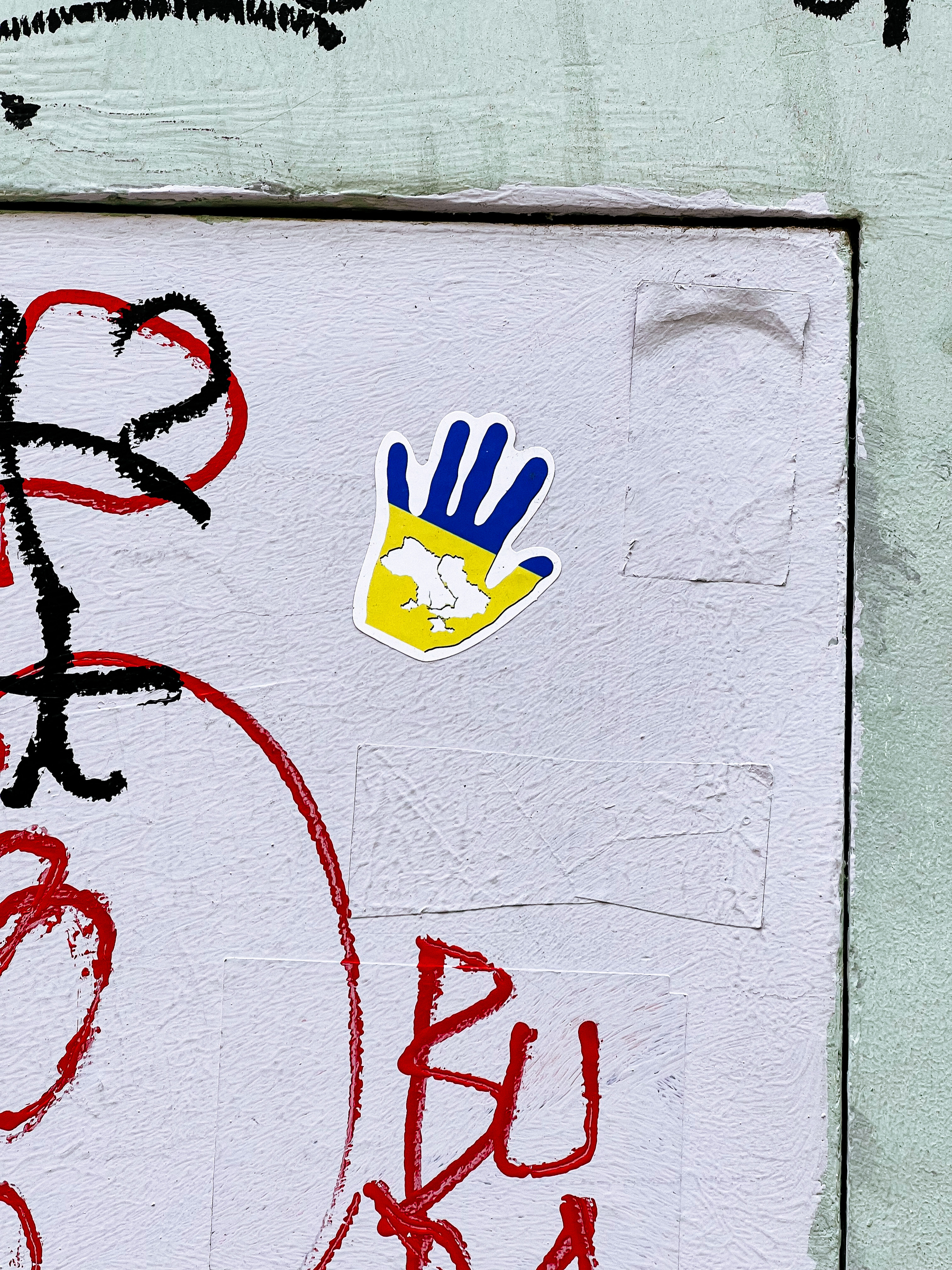 Sticker with a blue and yellow hand, with a map of Ukraine. 