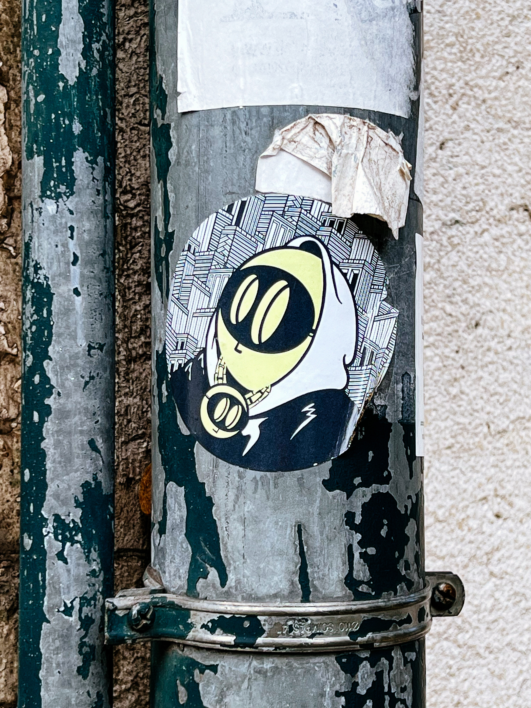 Sticker with a drawing of a face, with holes for eyes. 
