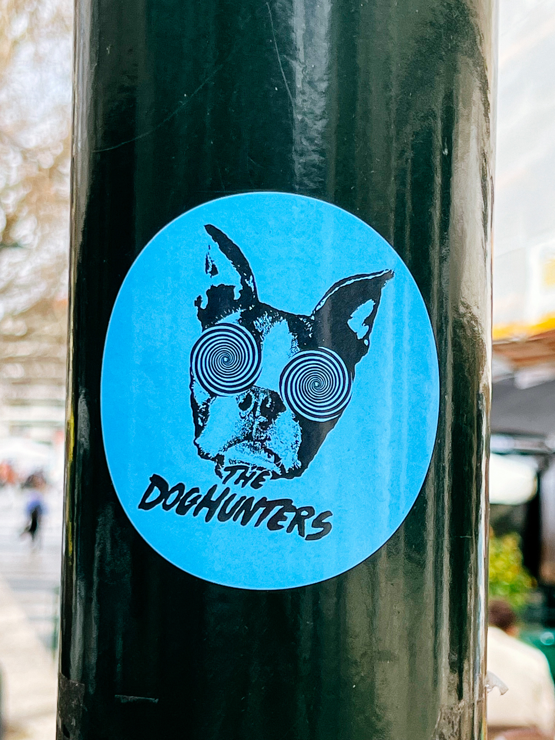 Sticker with a dog’s face, his eyes are hypnotized. The words “The Doghunters”. 