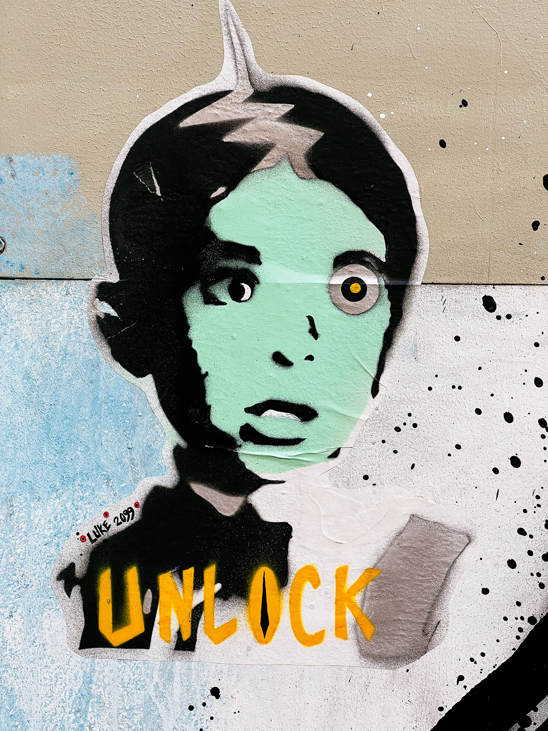 Spooky kid’s face on a sticker, with “unlock” written beneath it. 