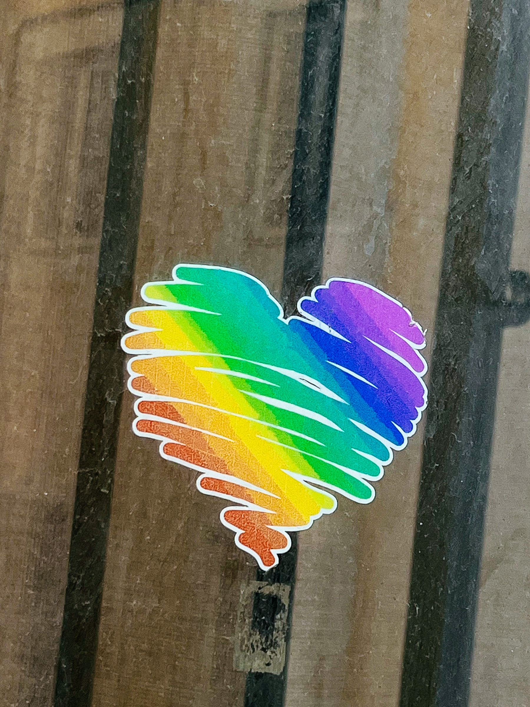 A rainbow colored heart sticker. 