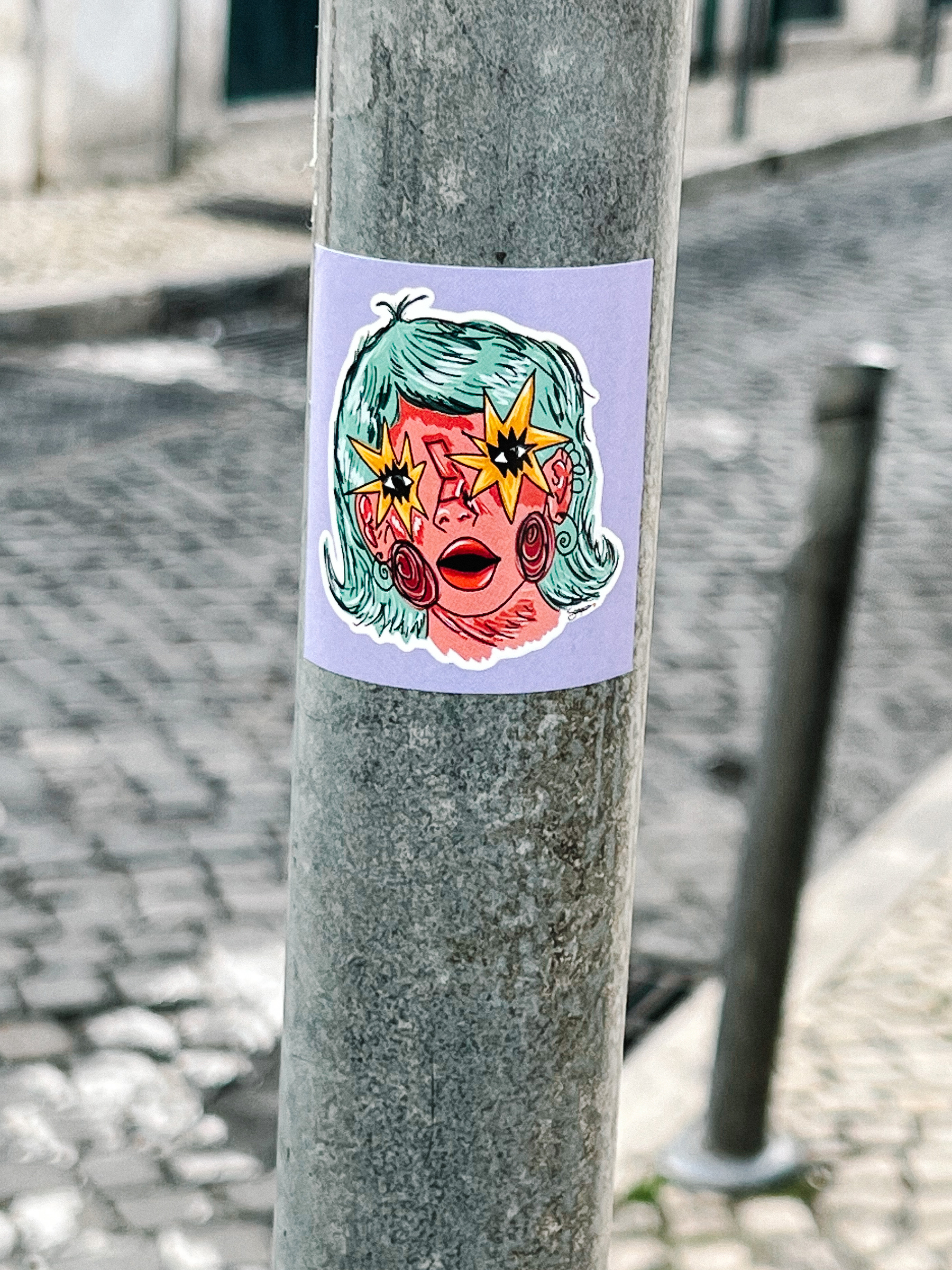 Sticker of a drawing. A women with stars for eyes, and blue hair. 