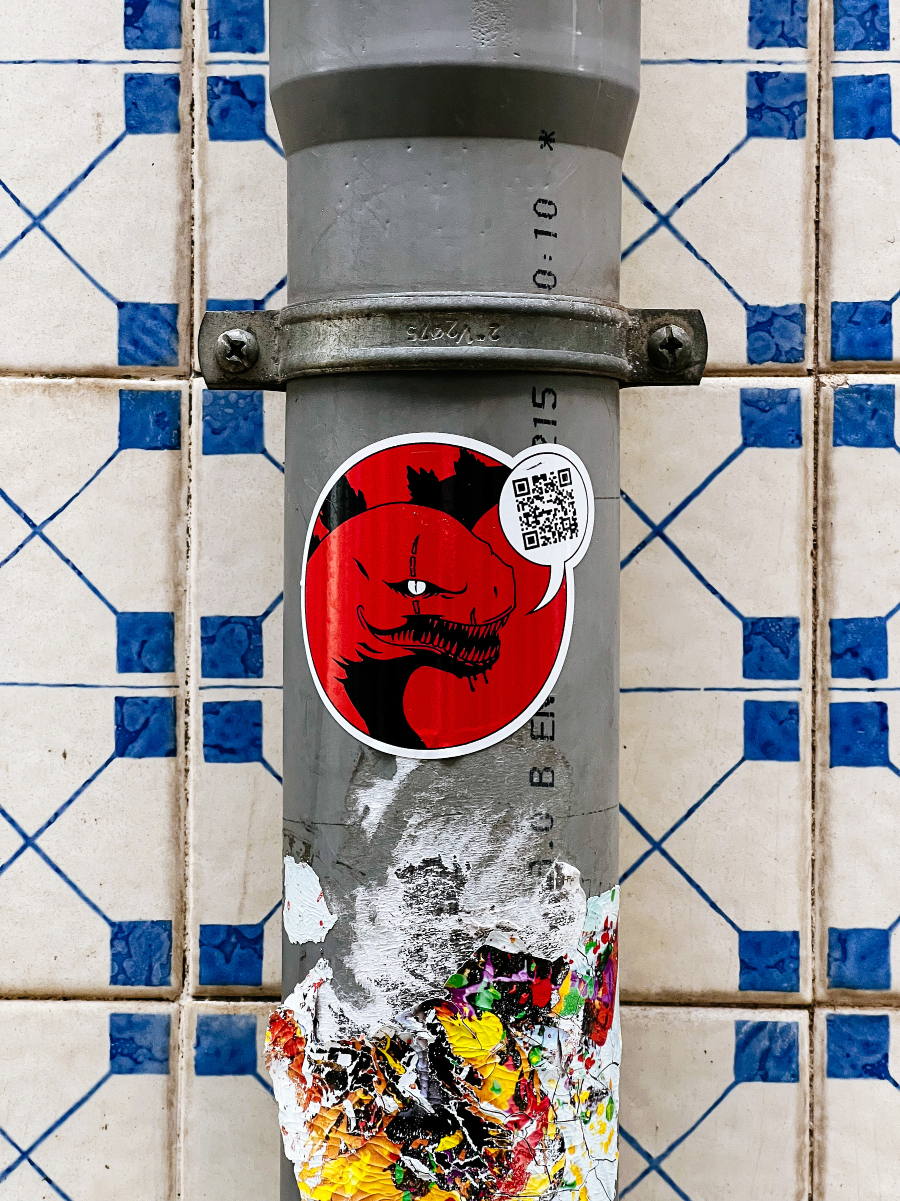 Sticker with a red, hellish looking, lizard. A speech bubble with a QR code close to his mouth. 