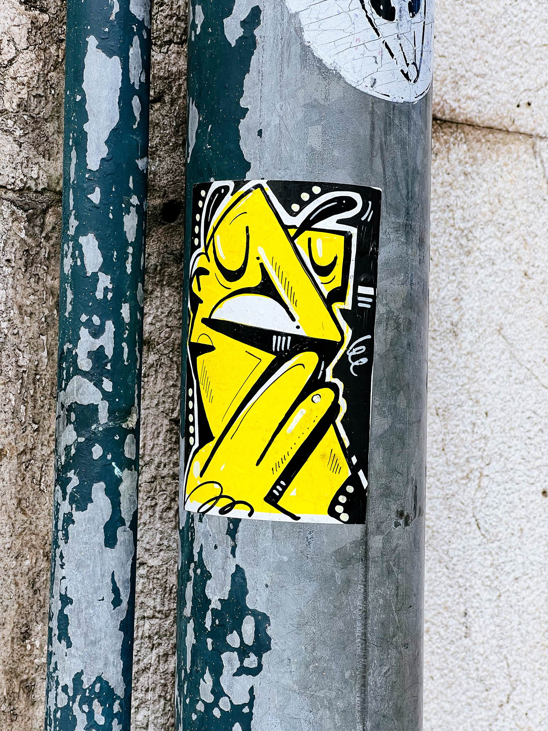 Sticker with a face, drawn in yellow, straight lines mostly. 
