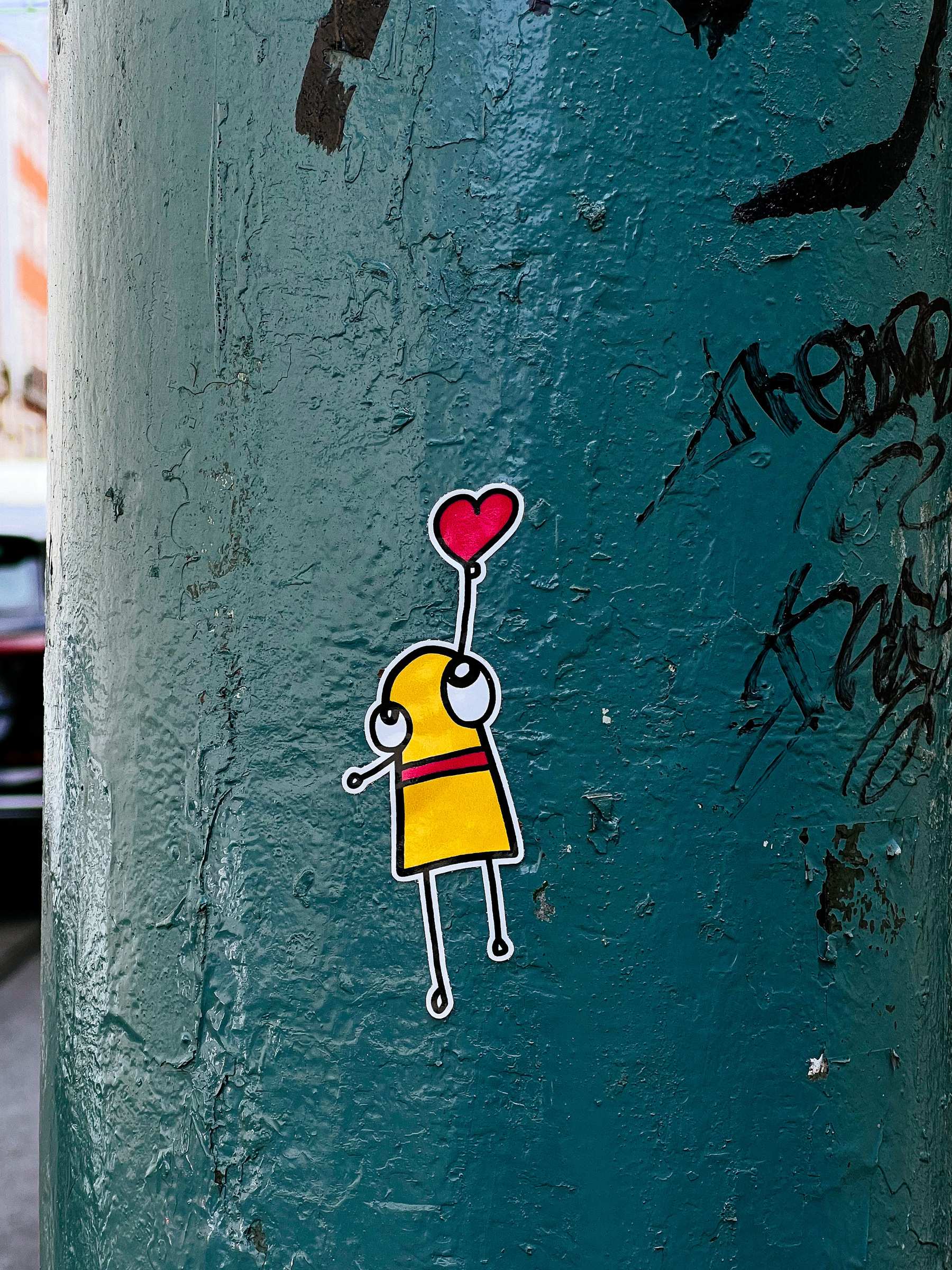 Sticker. A girl in yellow dress is being lifted by a heart shaped balloon. Cartoony. 