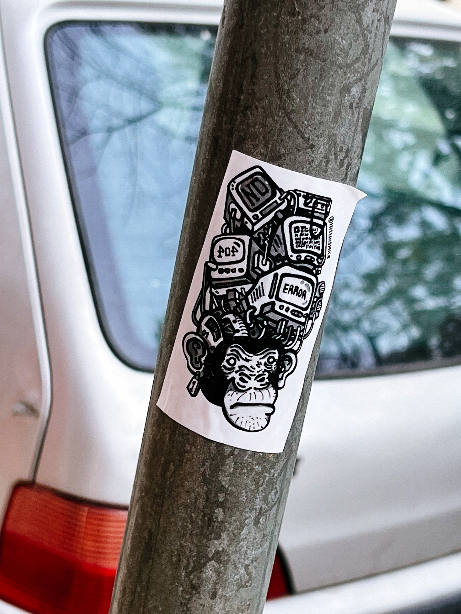 Sticker with a drawing of a monkey with a few computer monitors on his head. One reads “error”. 