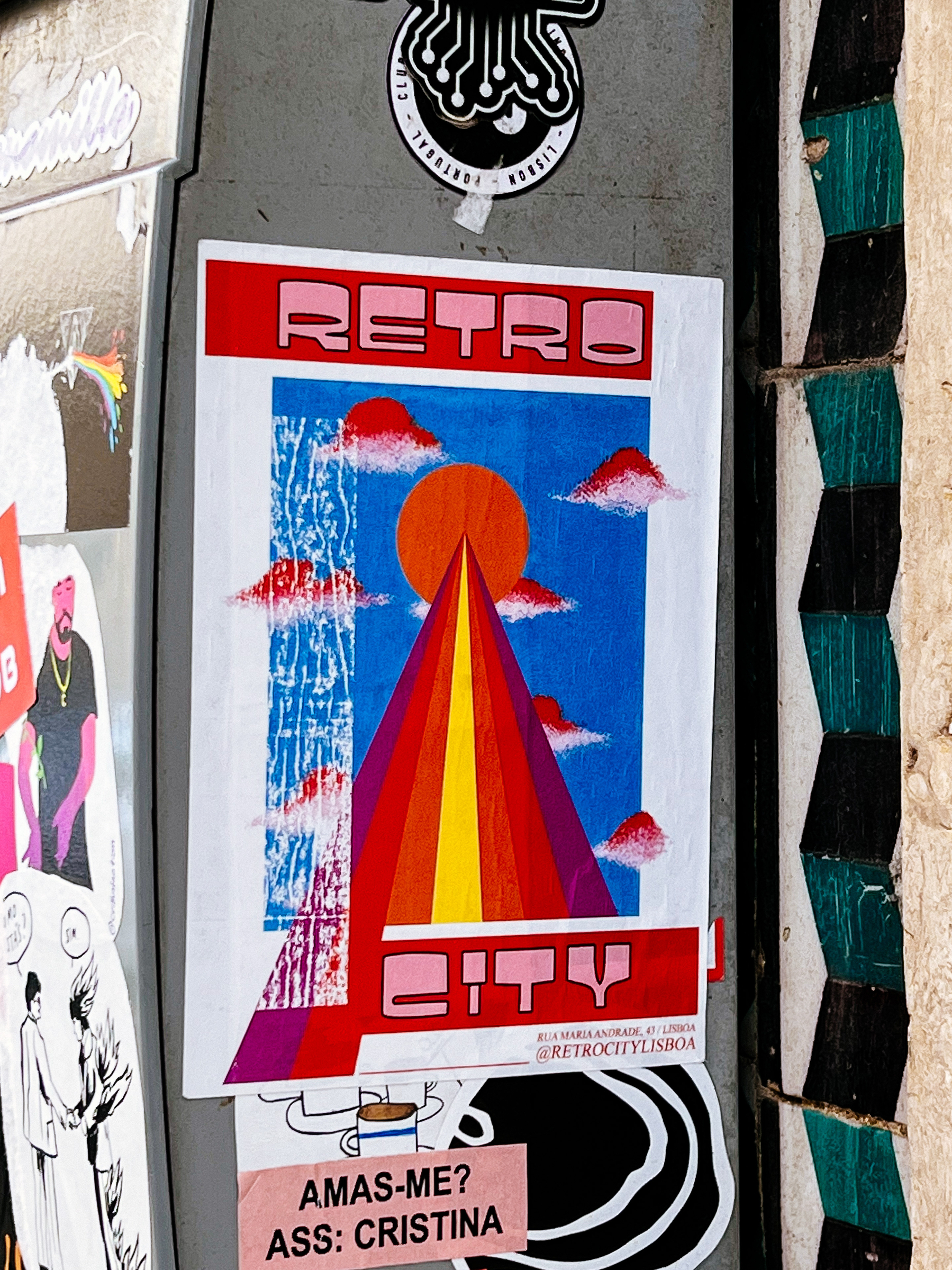 Sticker with the words “Retro City”, on a retro font, and a red/orange/yellow “road” leading to a red sun.