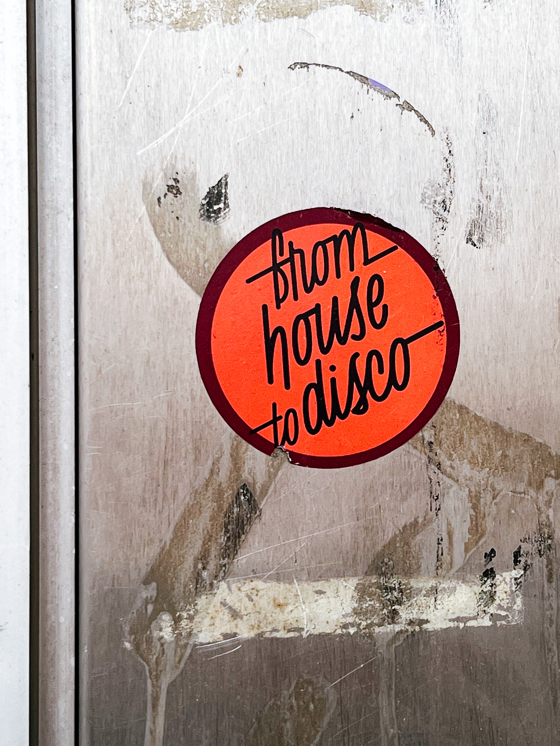 Round red sticker with the words “from house to disco”. 