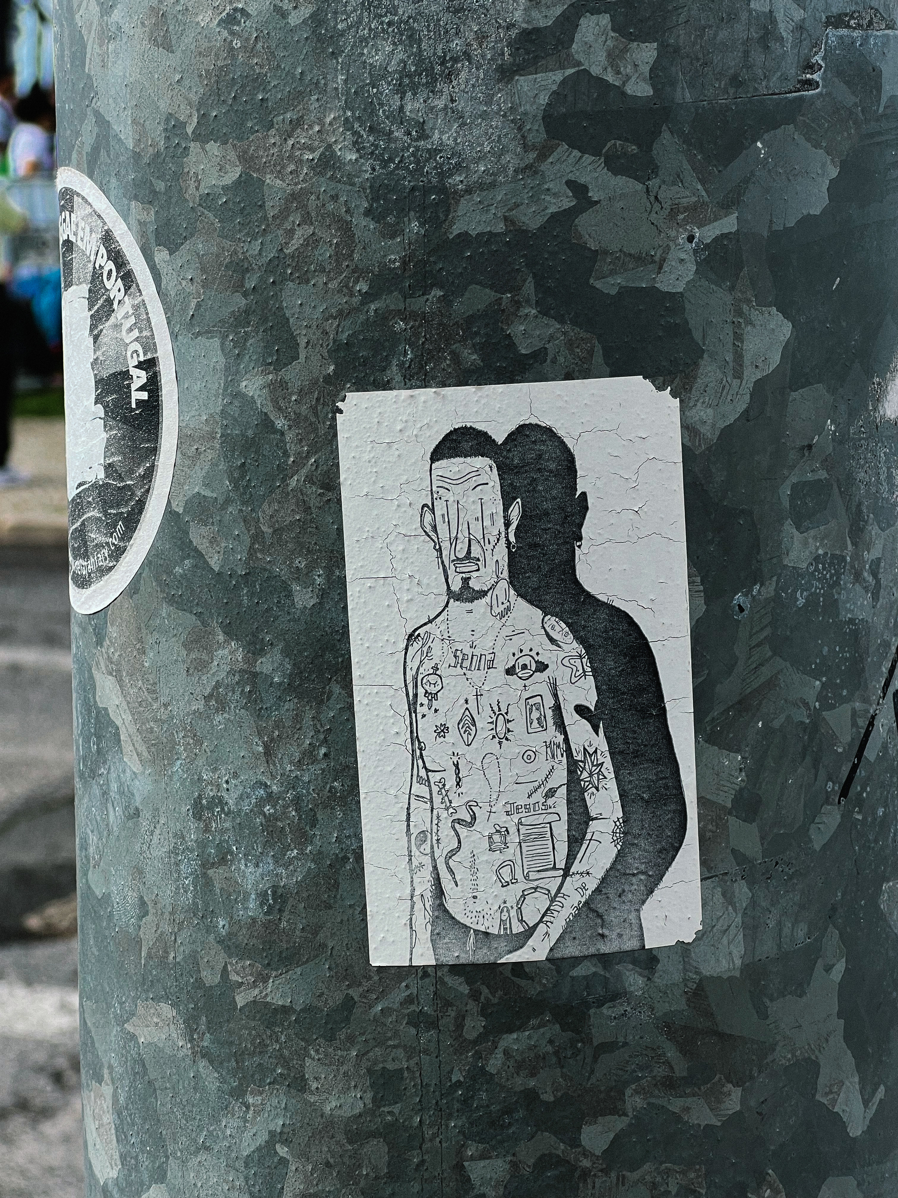 Sticker with a drawing of a man with tattooed torso. 