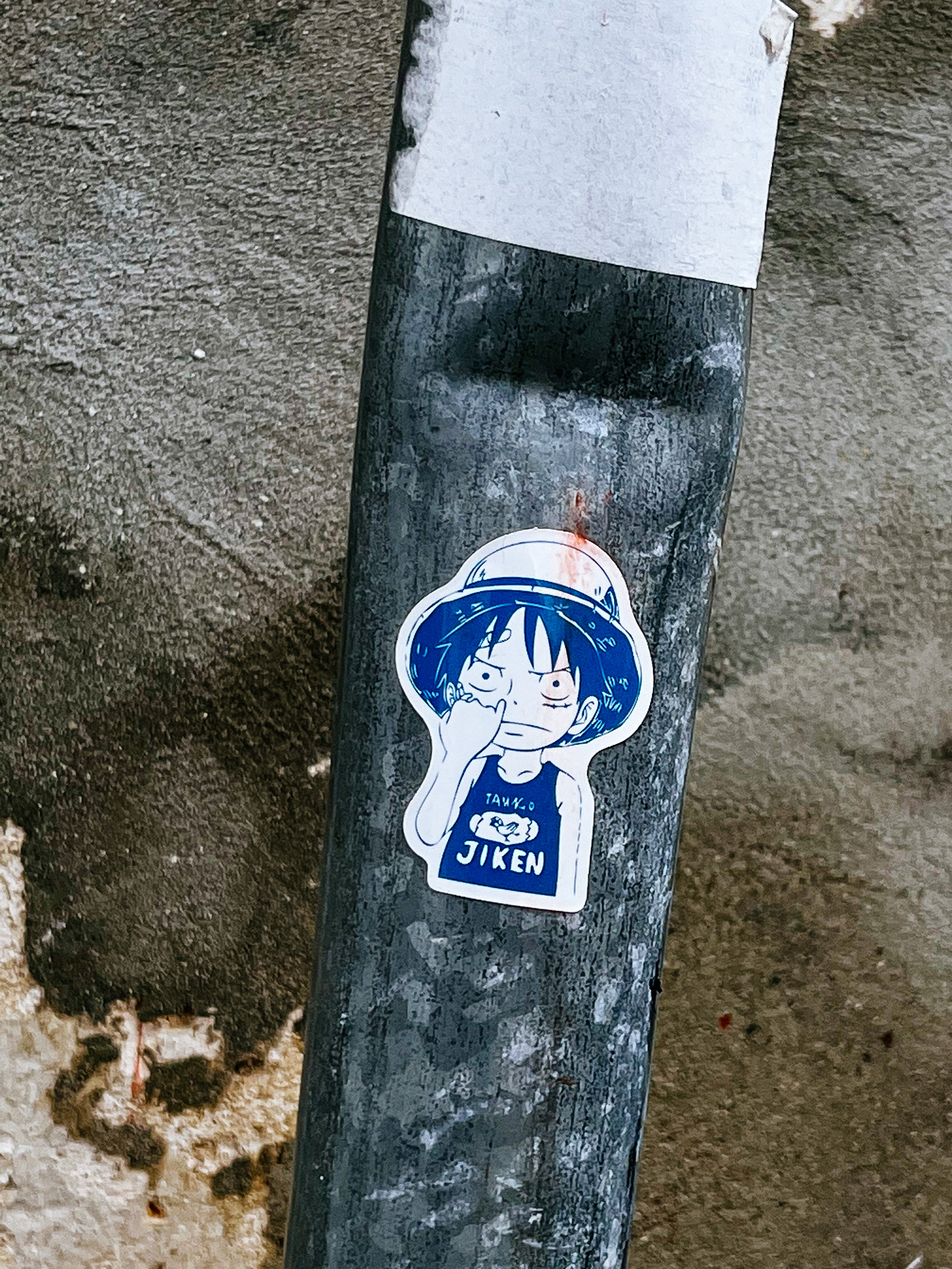Sticker with a manga character, wearing a shirt with the word “Jiken”, and a hat. 