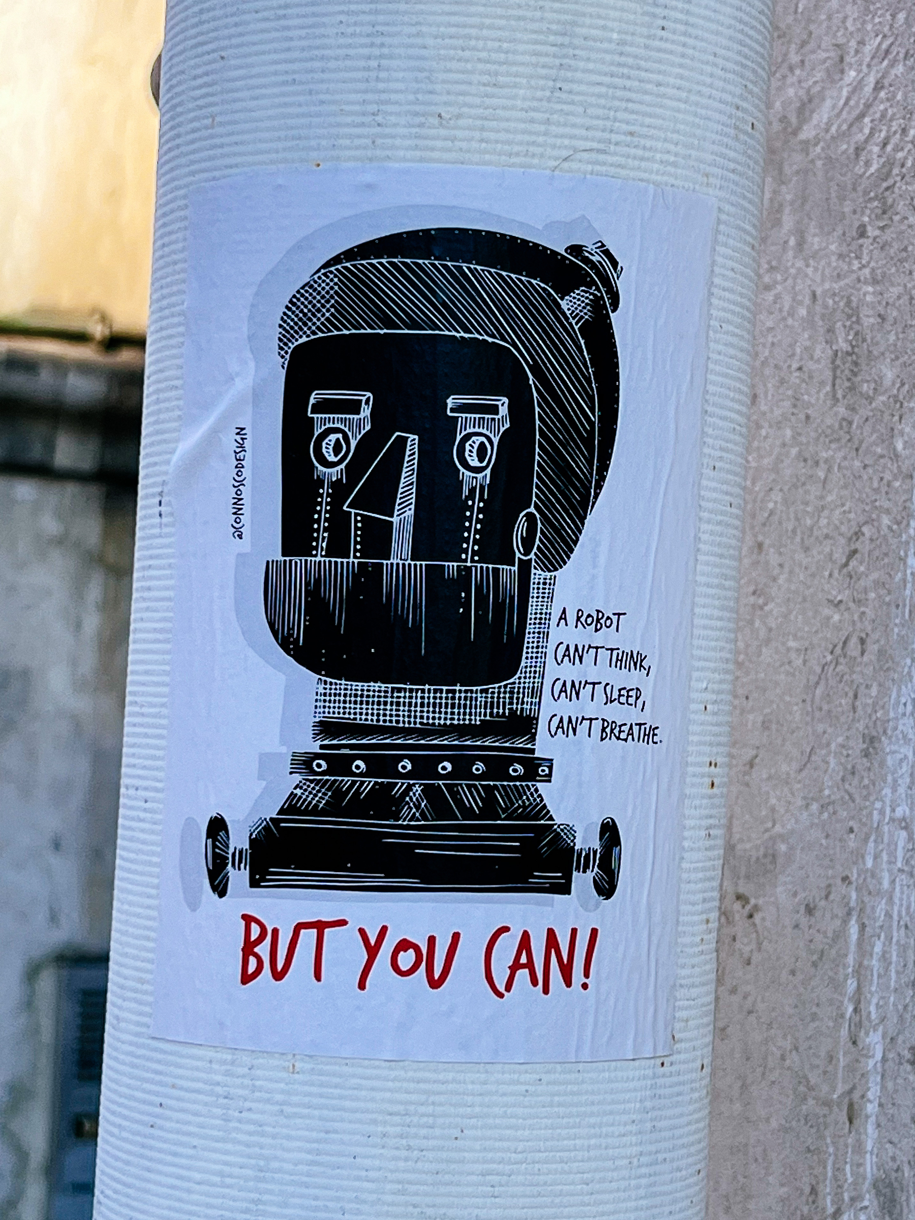 Sticker of a drawing of a robot’s head, with the words “A robot can’t think, can’t sleep, can’t breathe. But you can” next to it. 