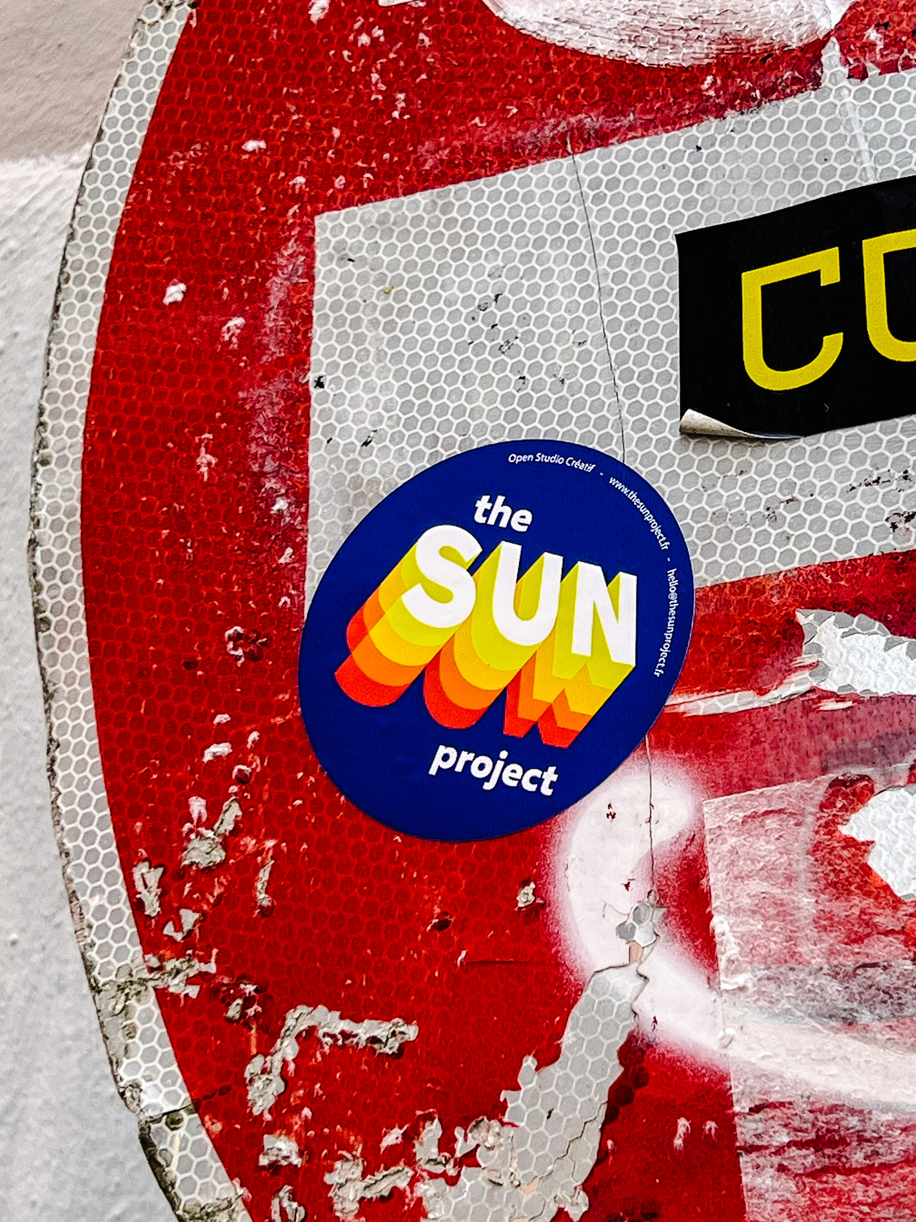 Sticker with “The Sun Project”. The word “Sun” has a 3D effect. 