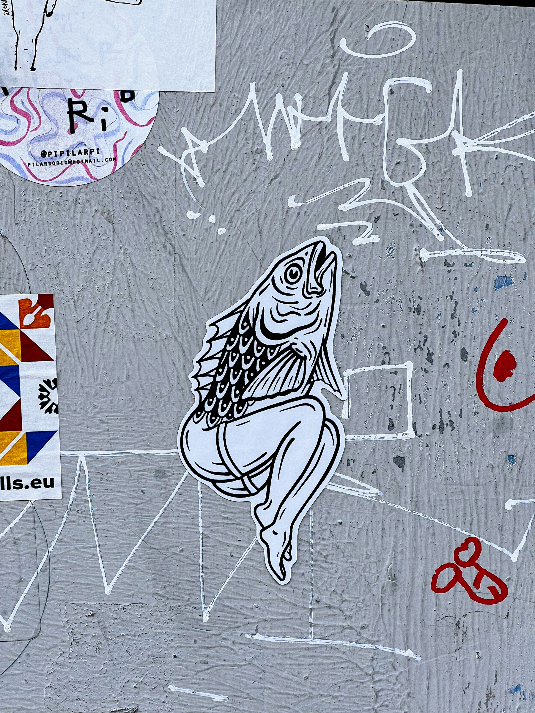Sticker of a drawing. A figure, half part of the body is a fish, bottom a women’s legs. 