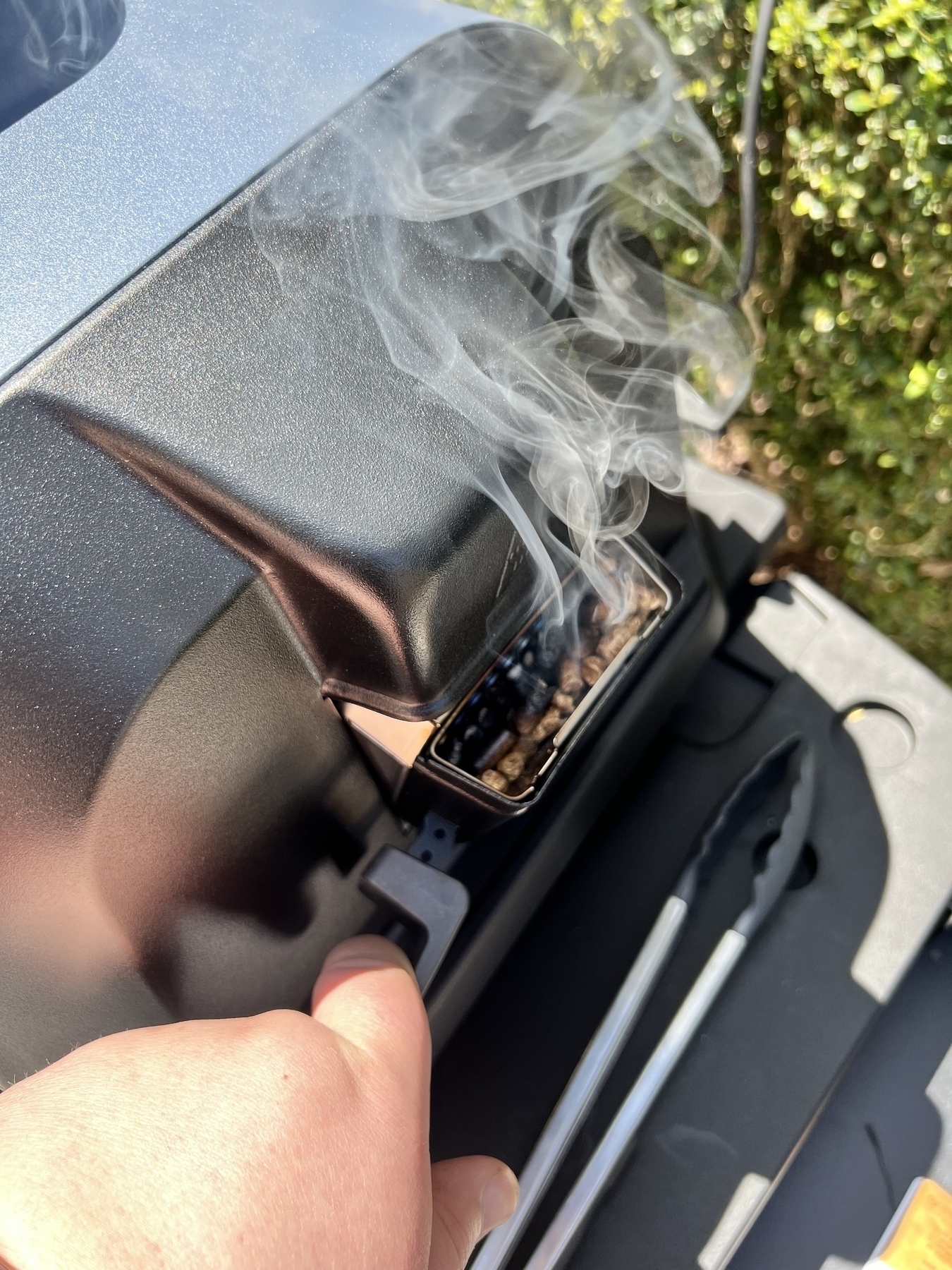 Smoking box of wood pellets on the side of the grill