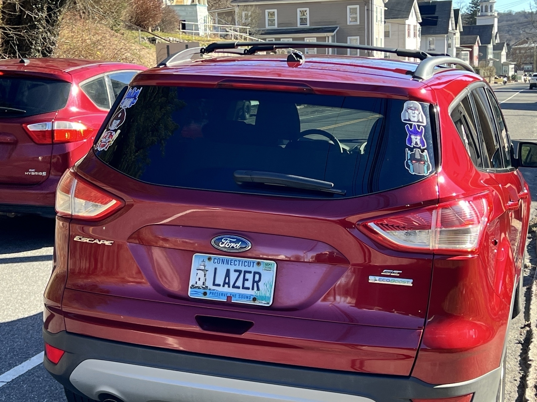 Red car with the license plate “lazer” and transformers stickers all over the windows. 