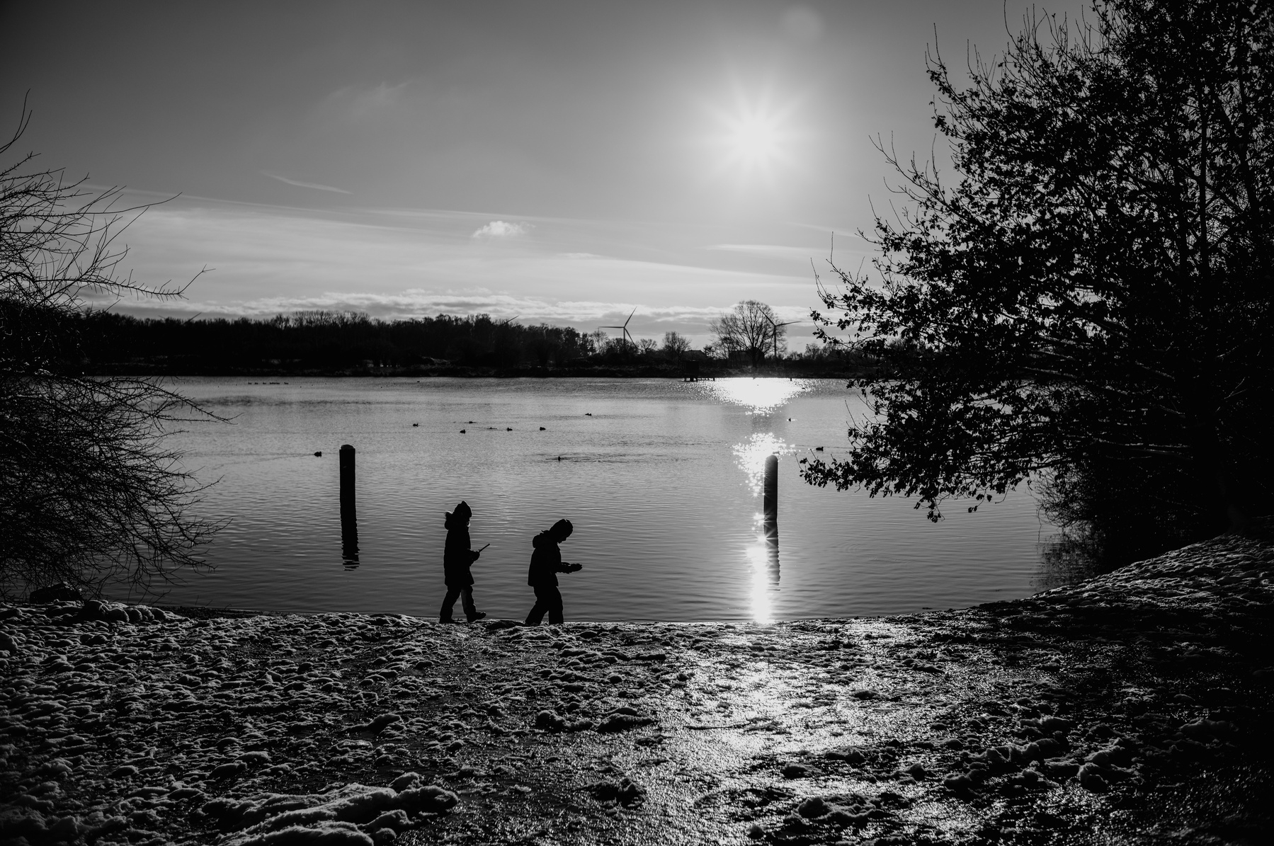 Children playing at the river, surrounded by ice and snow