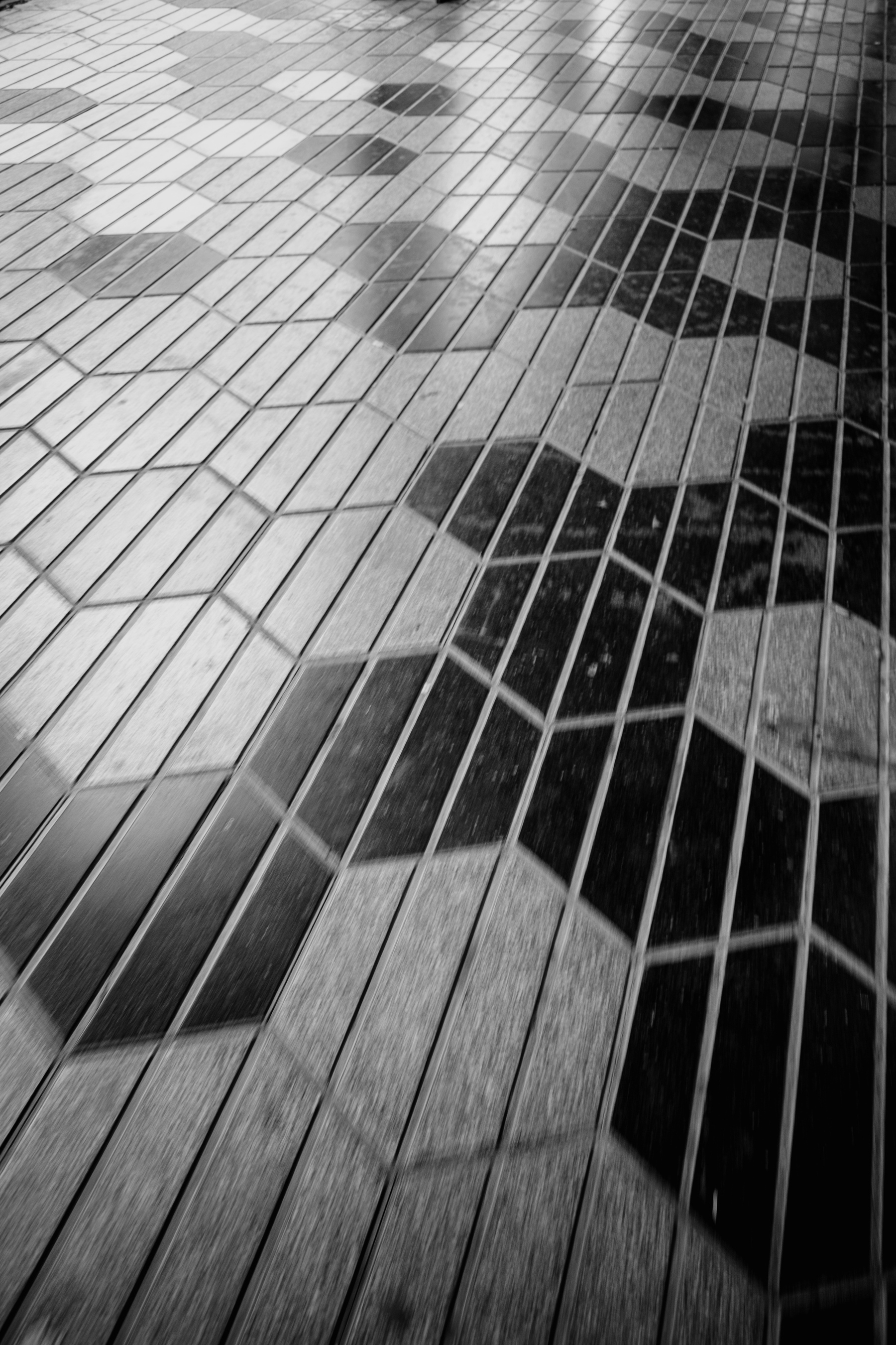 A black and white, patterned tiled floor with a geometric design consisting of hexagons and parallelograms.