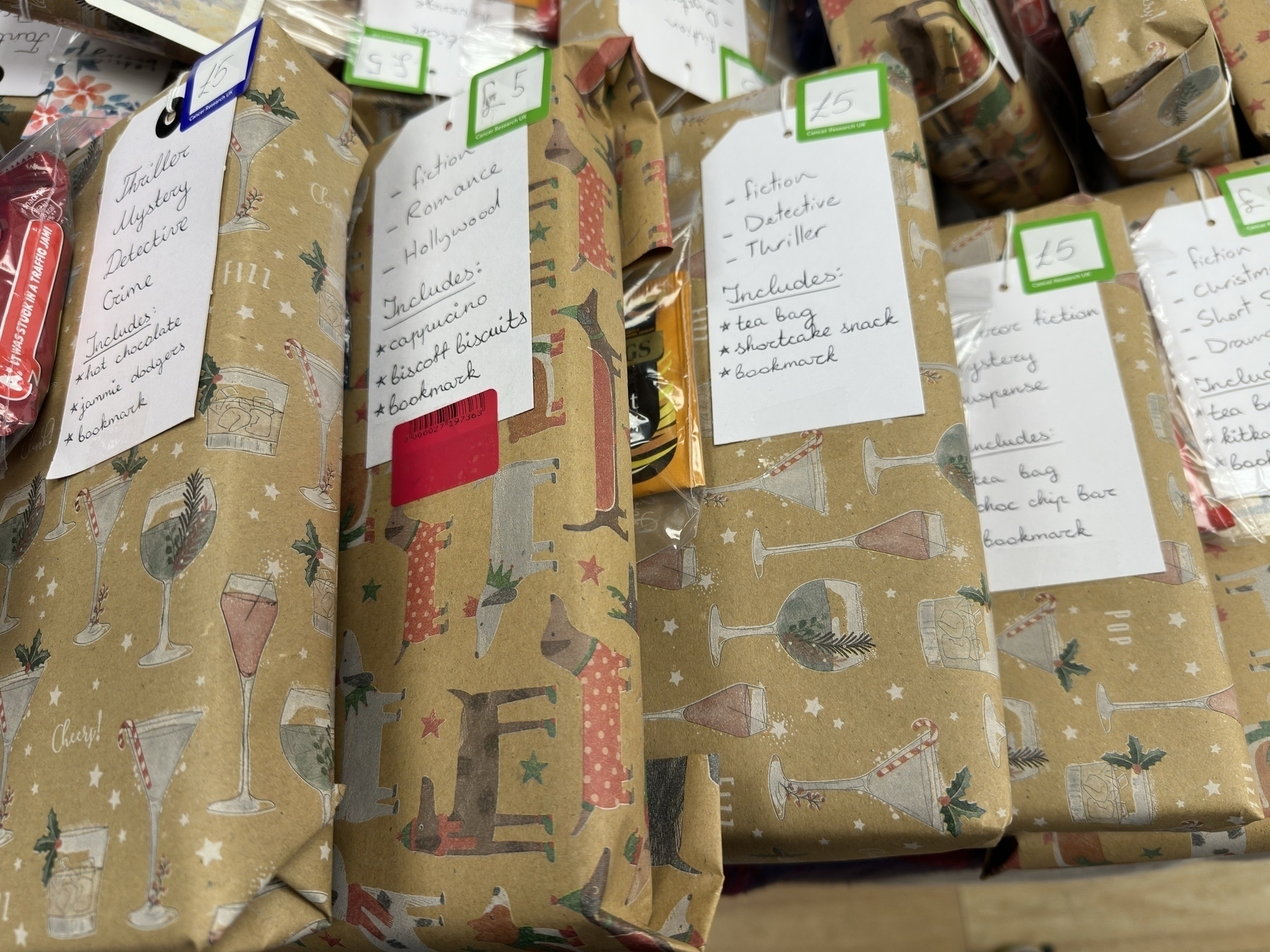 Several gift-wrapped mystery books are arranged, each labeled with genres and a price.