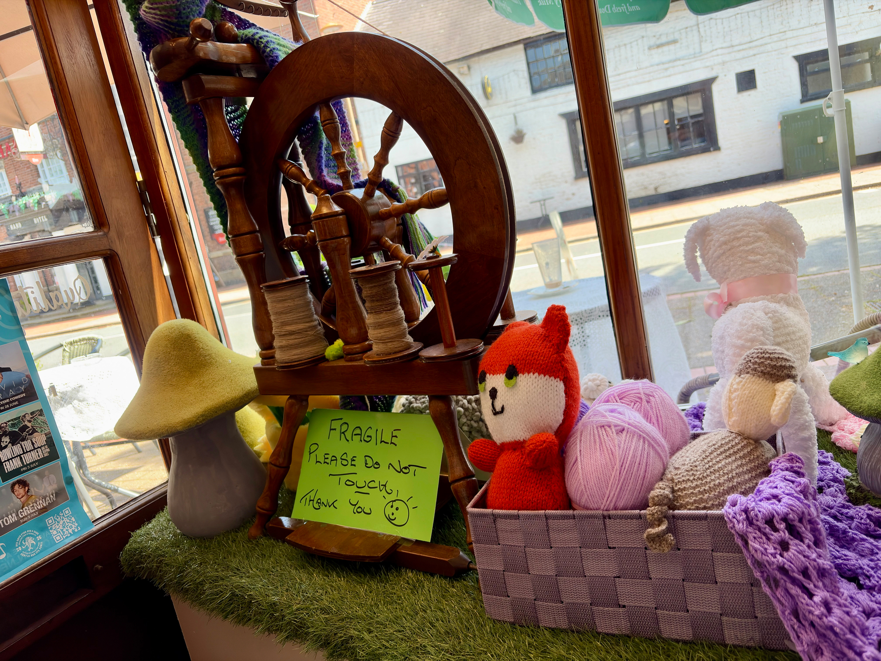 An old-fashioned spindle, with teddy bears. The sign reads Fragile. Please do not touch.