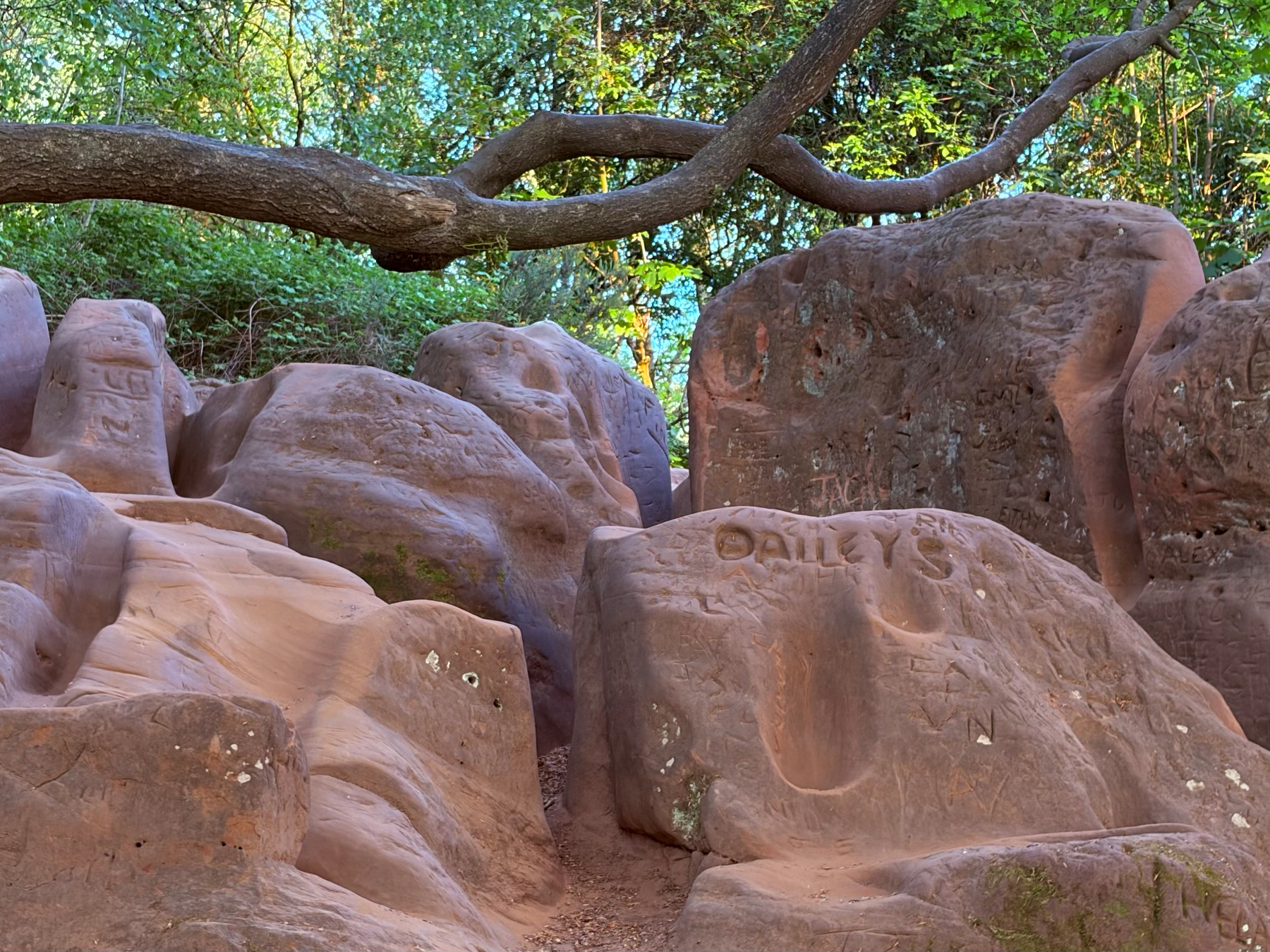 Large sandstone rocks with graffiti carved on them.