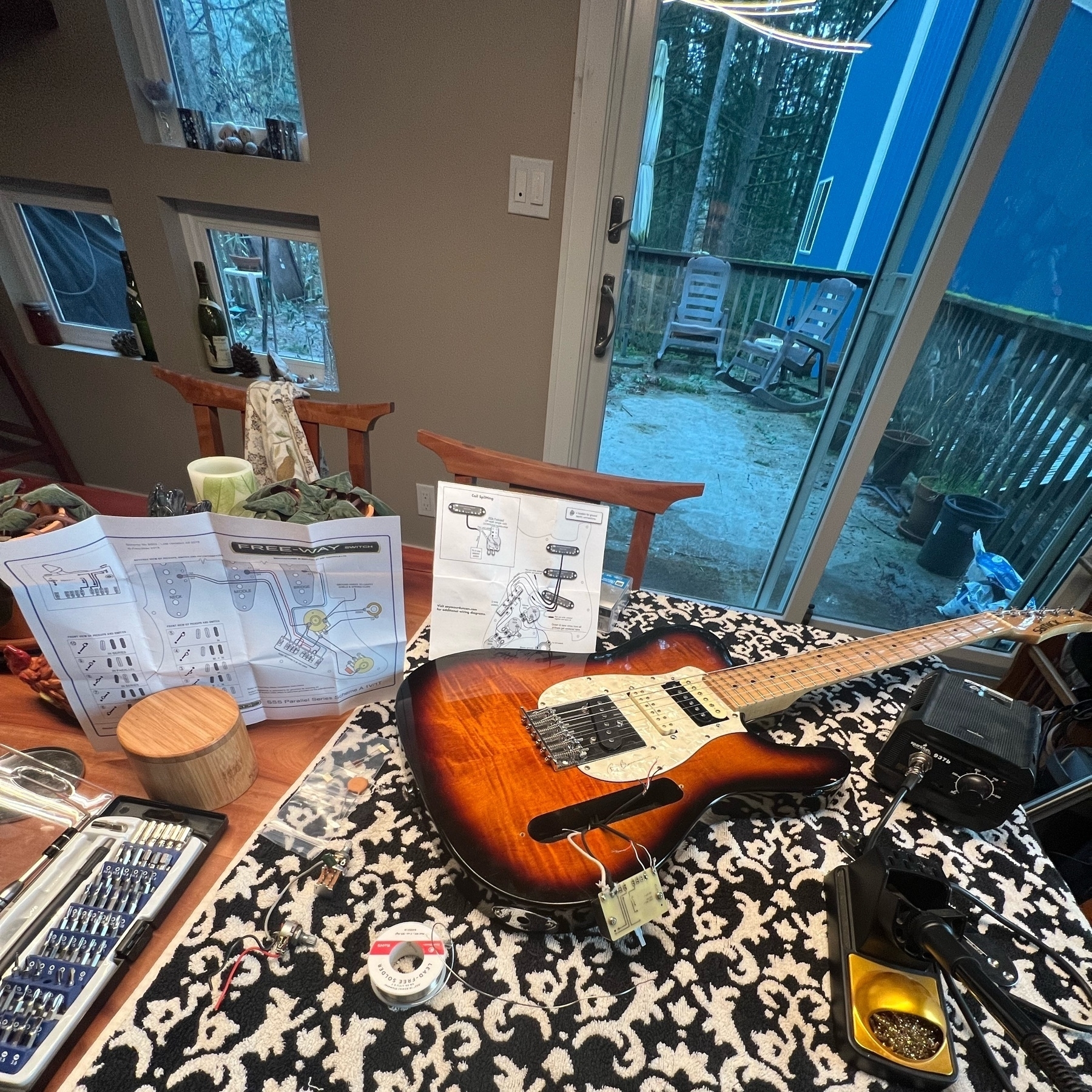 Electric guitar's electronics being assembles on a table